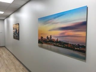 A hallway with a painting of a city skyline on the wall.