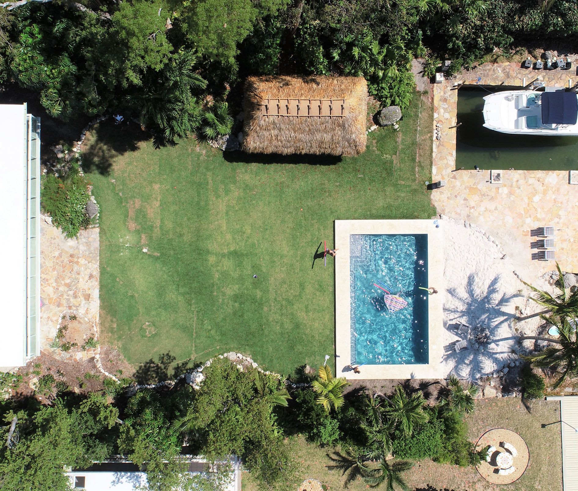 An aerial view of a swimming pool with a boat in the background