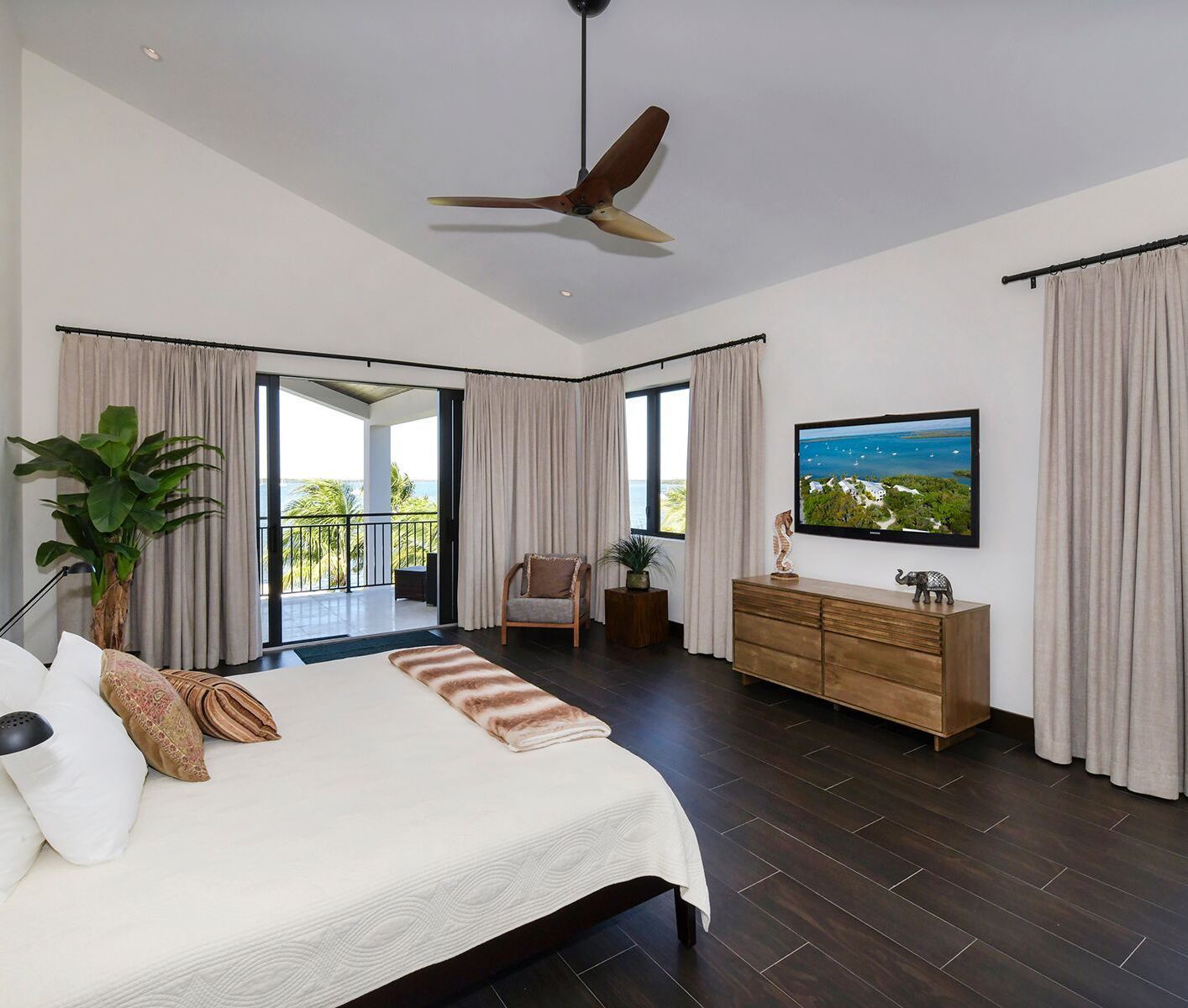 A bedroom with a large bed and a television on the wall