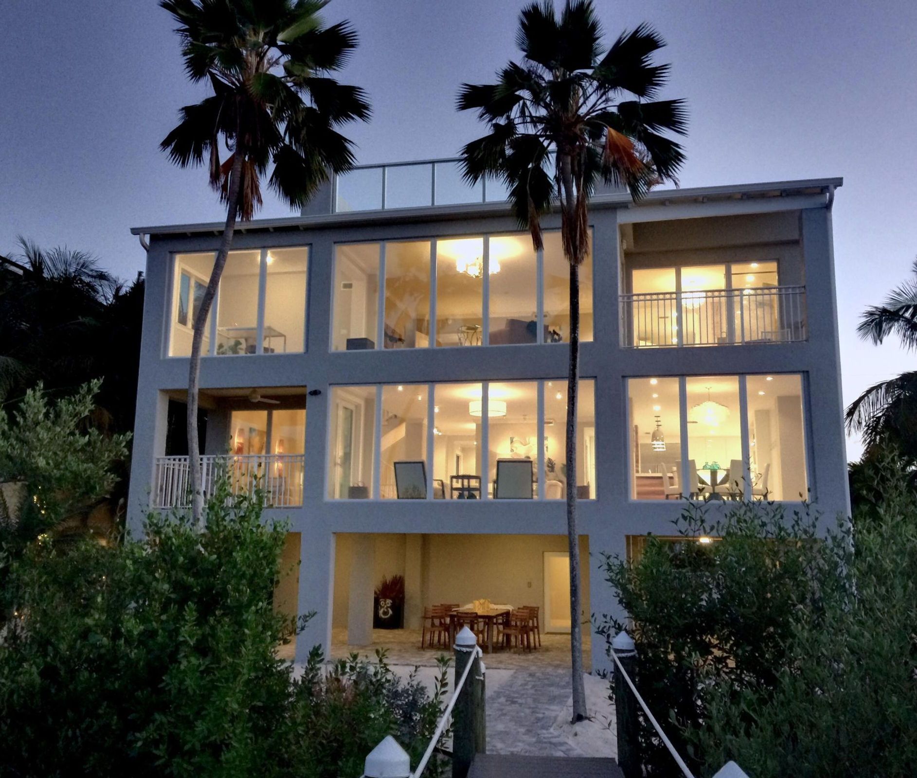 A large house with lots of windows is lit up at night