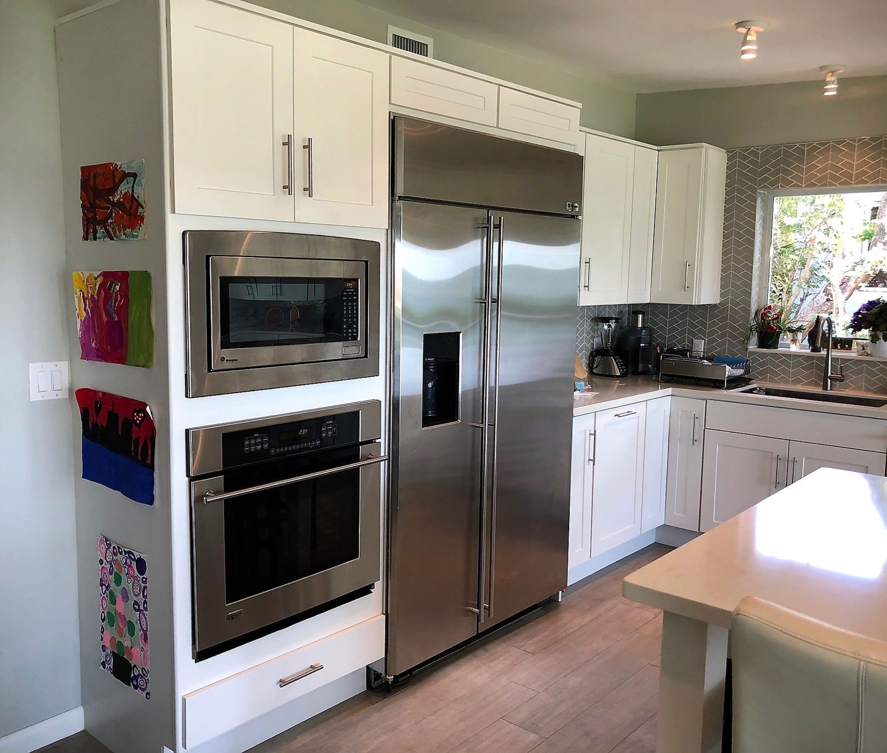A kitchen with stainless steel appliances and white cabinets