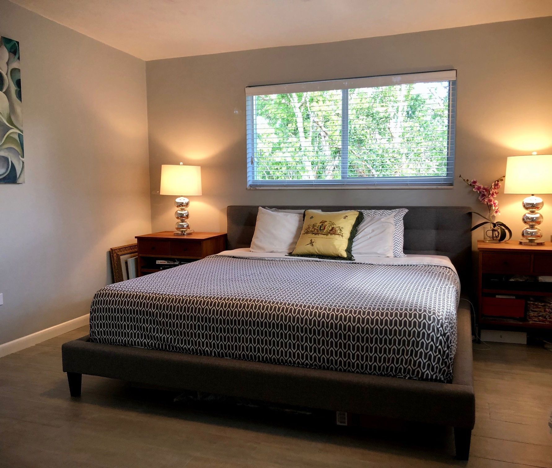 A bedroom with a large bed and two lamps