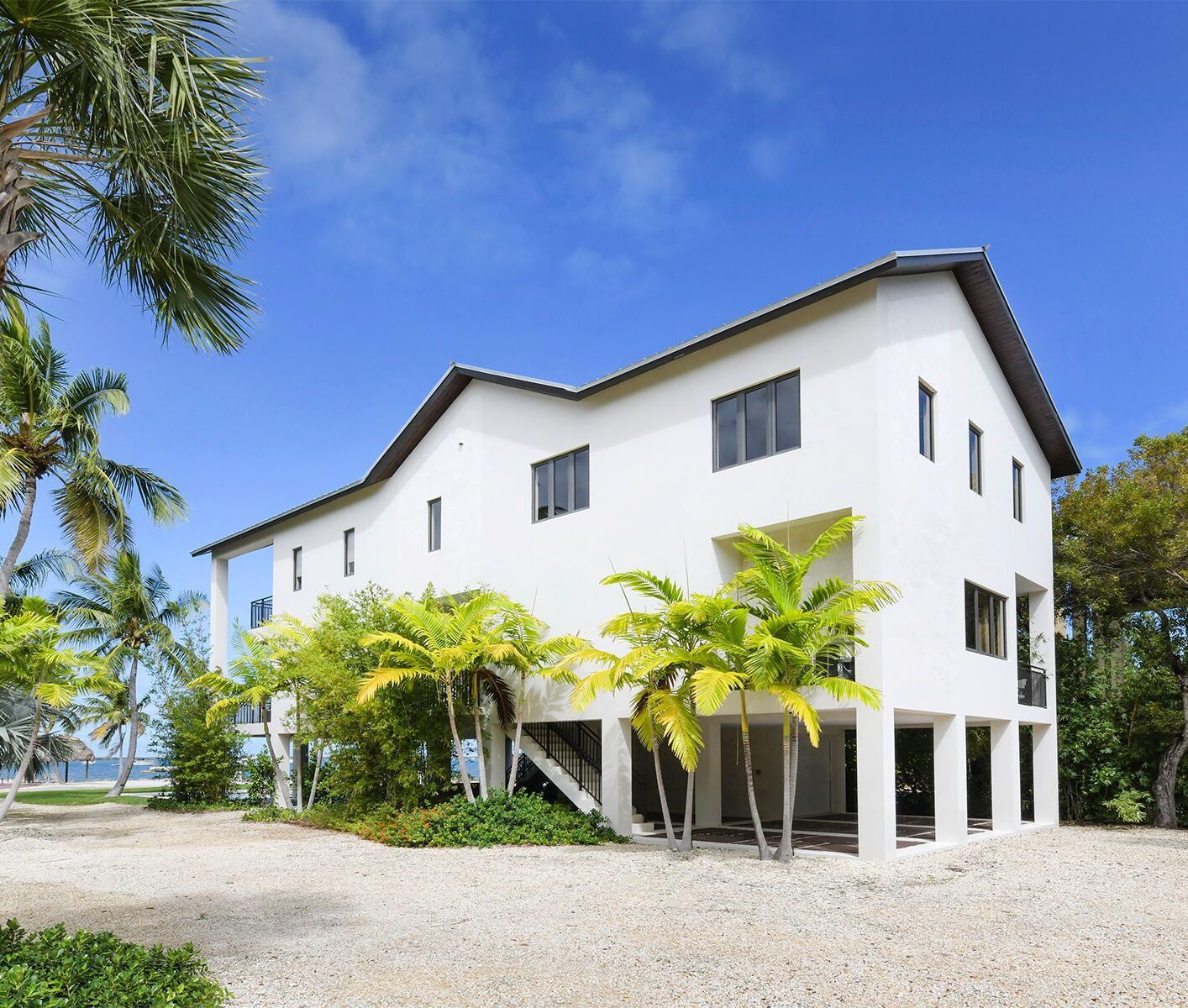 A large white house with palm trees in front of it