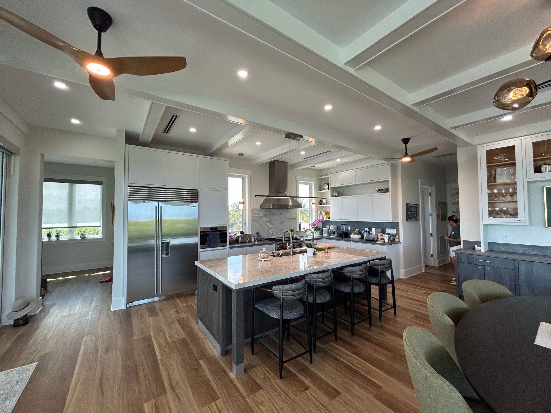 A kitchen with a large island and a ceiling fan.