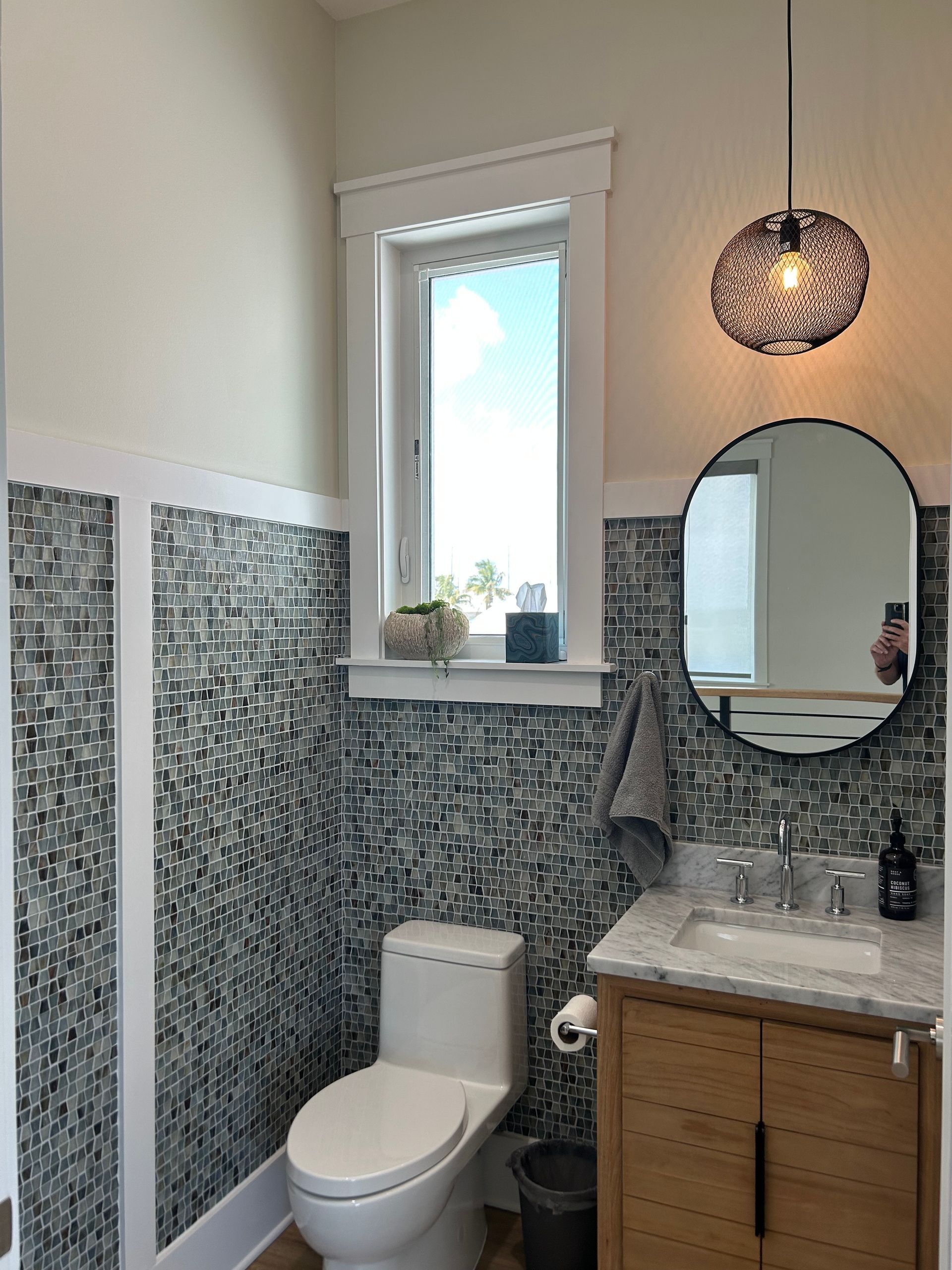 A bathroom with a toilet a sink and a mirror