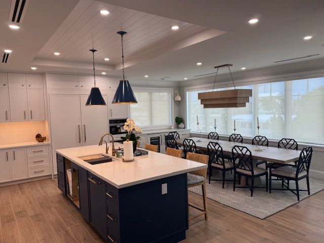 A kitchen and dining room in a house with a large island in the middle.