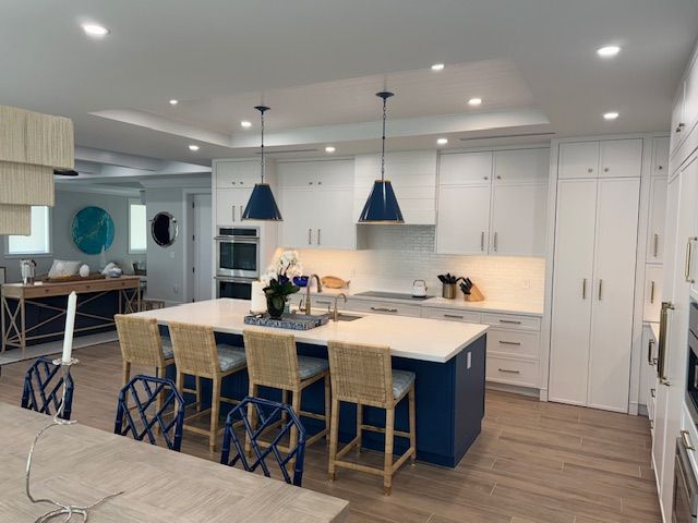 A kitchen with a blue island and white cabinets
