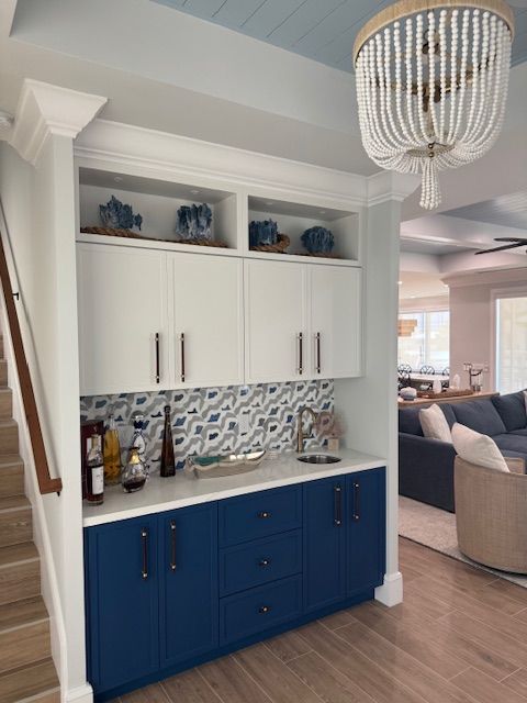 A kitchen with blue cabinets and white counter tops