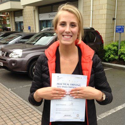 smiling woman with driving test certificate
