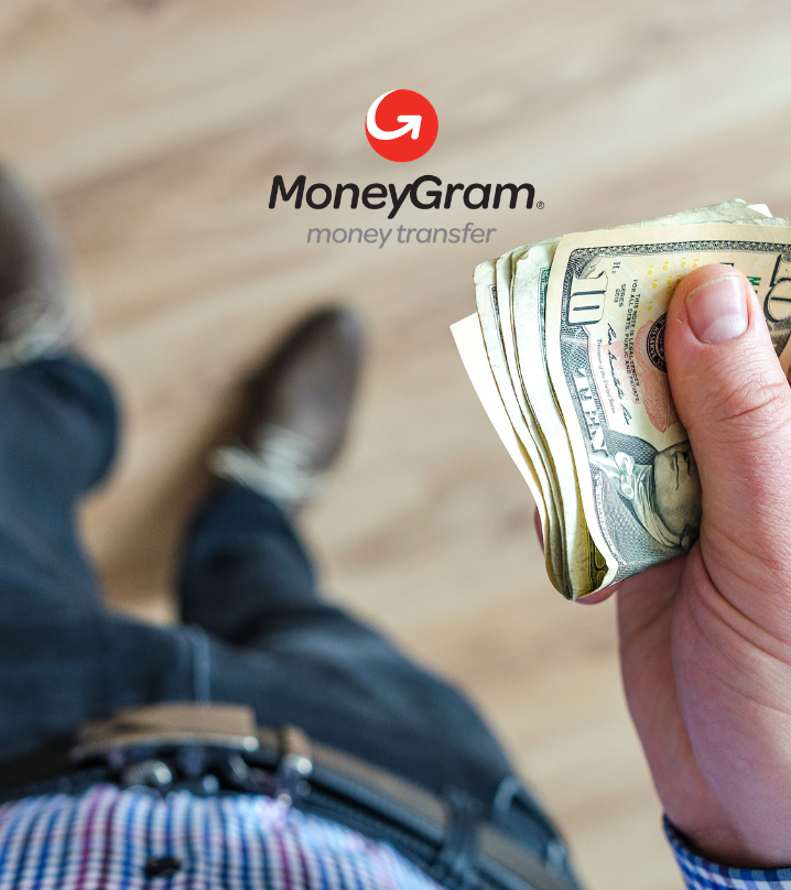 uma pessoa está segurando uma pilha de dinheiro na frente de um logotipo do moneygram