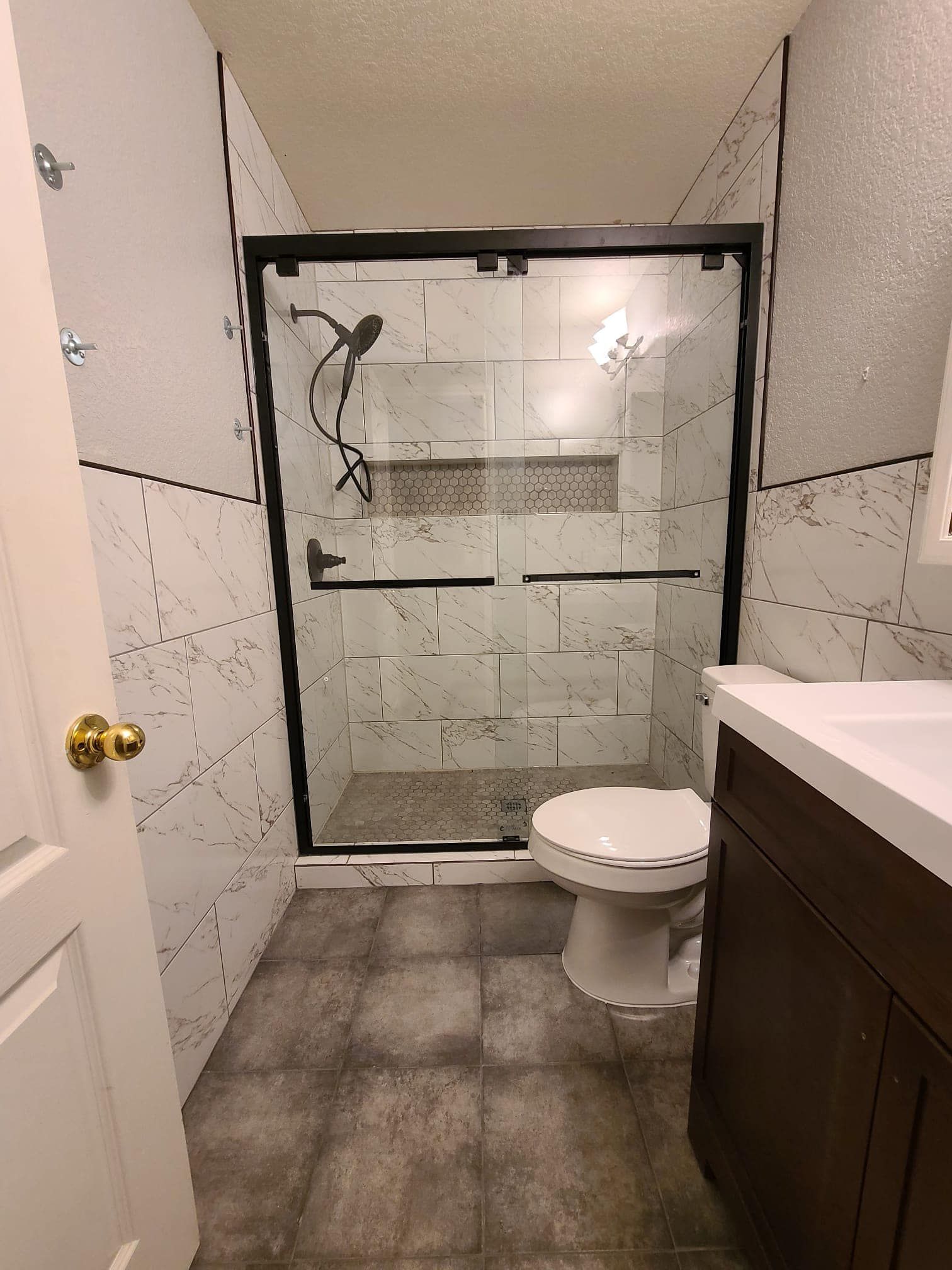 A bathroom with a toilet , sink and shower.