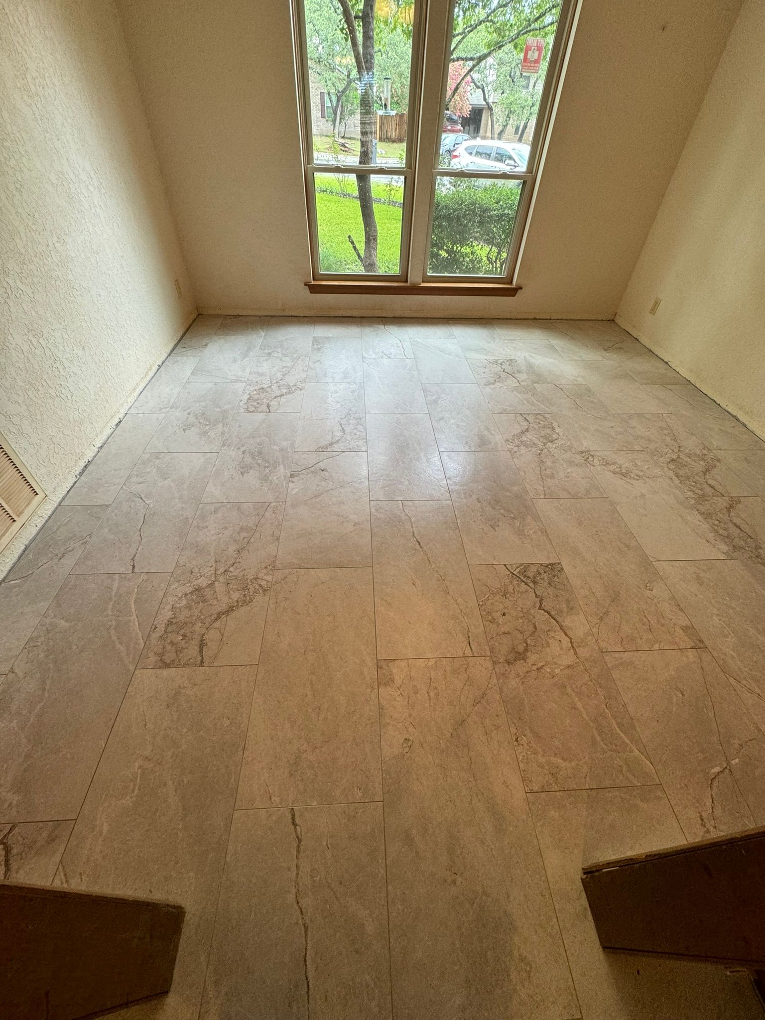An empty room with a wooden floor and a window.