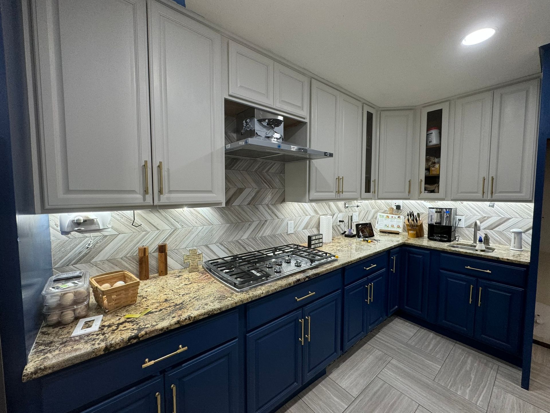 A kitchen with blue cabinets and a stove top oven.