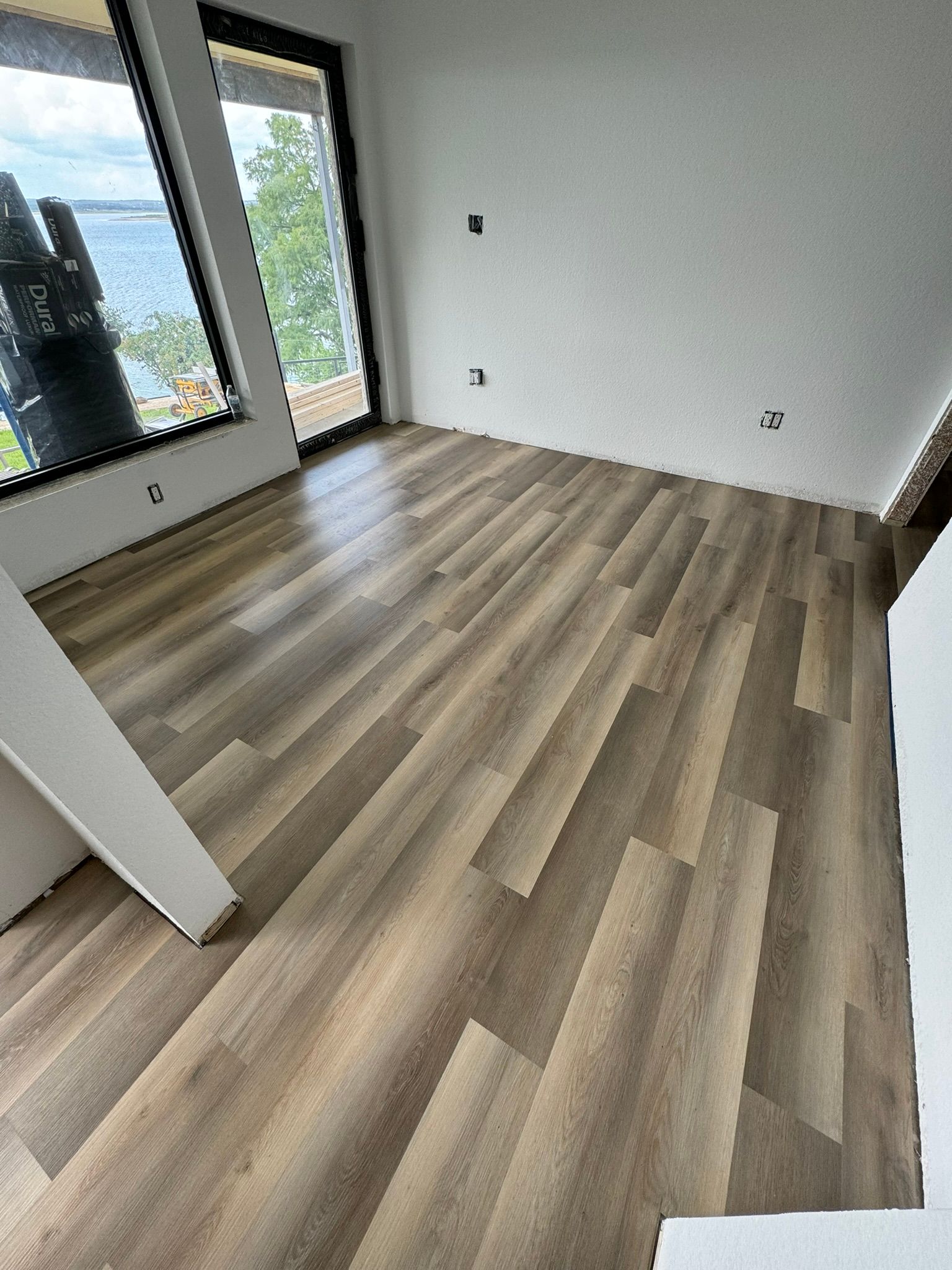 A room with a wooden floor and a lot of windows.