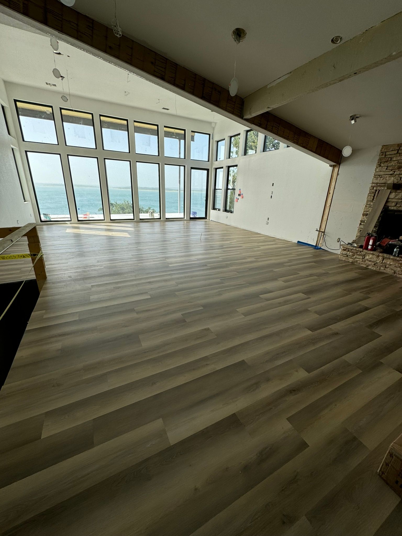 A large empty room with a lot of windows and a fireplace.