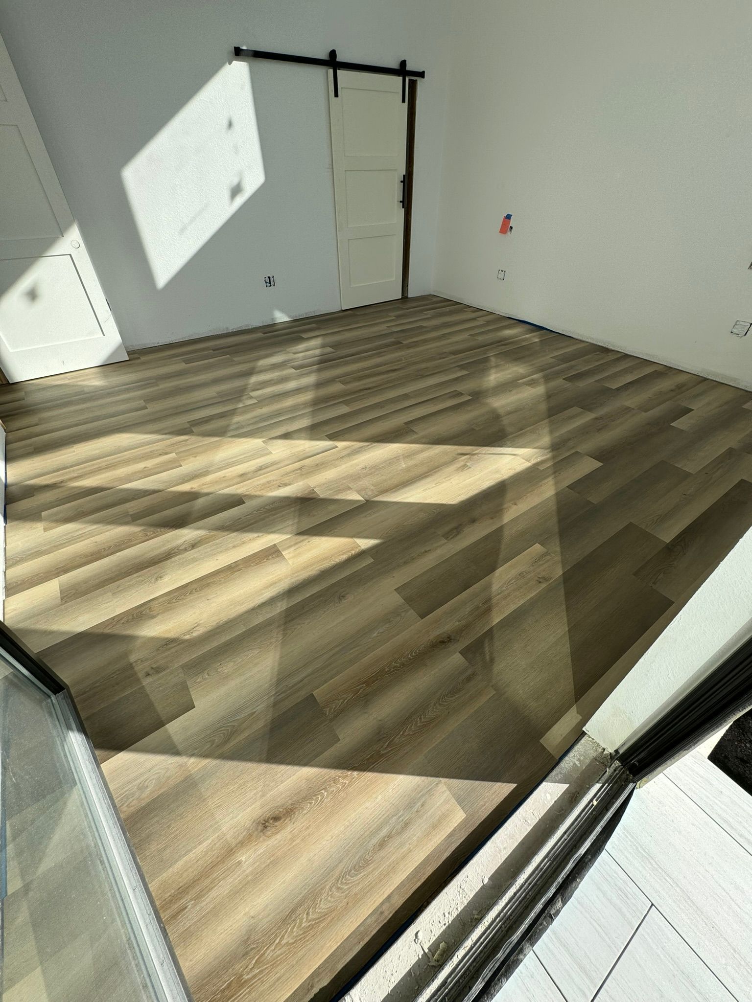 A room with a wooden floor and a sliding barn door.