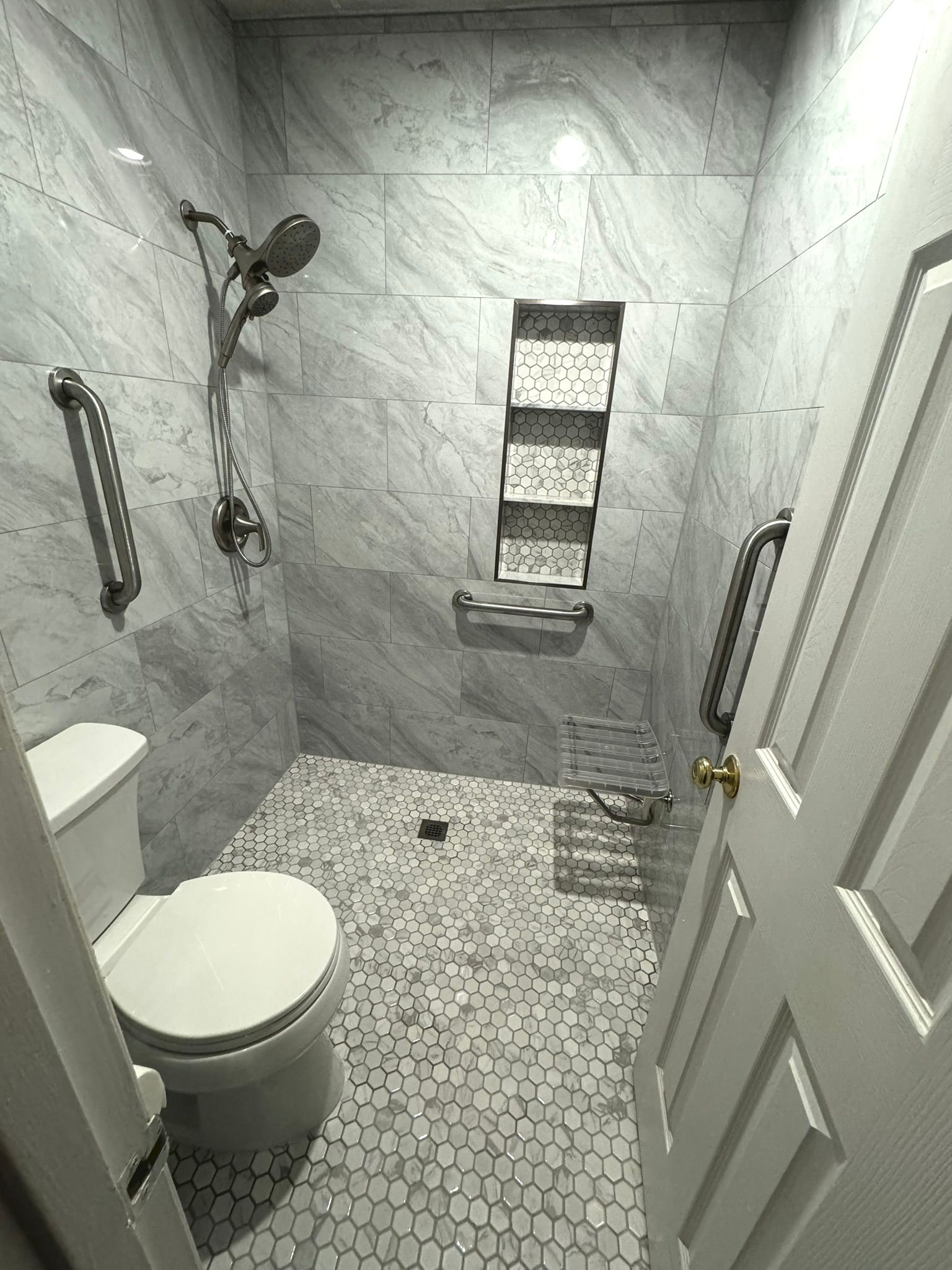 A bathroom with a toilet and a walk in shower.