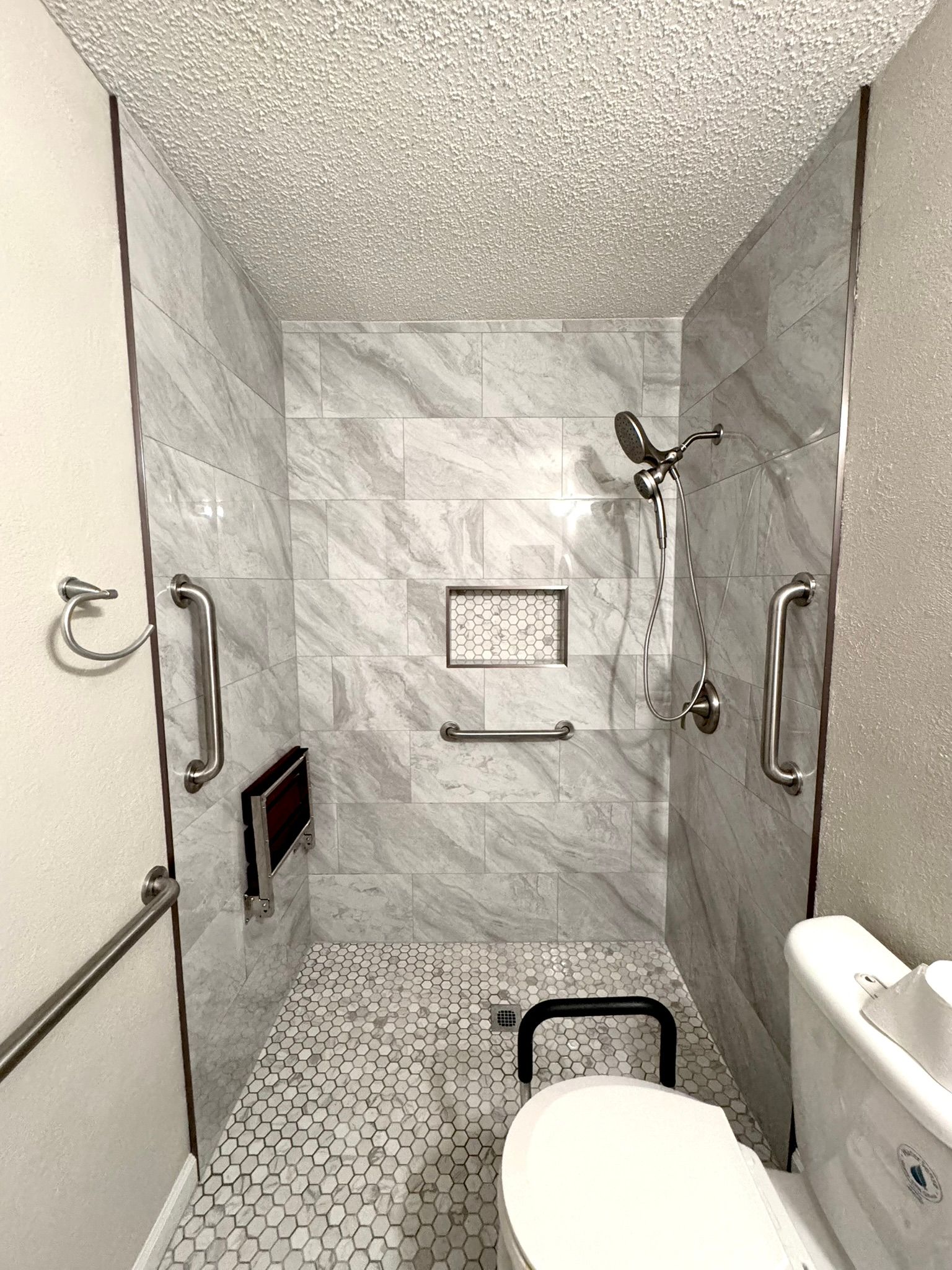 A bathroom with a toilet and a walk in shower.