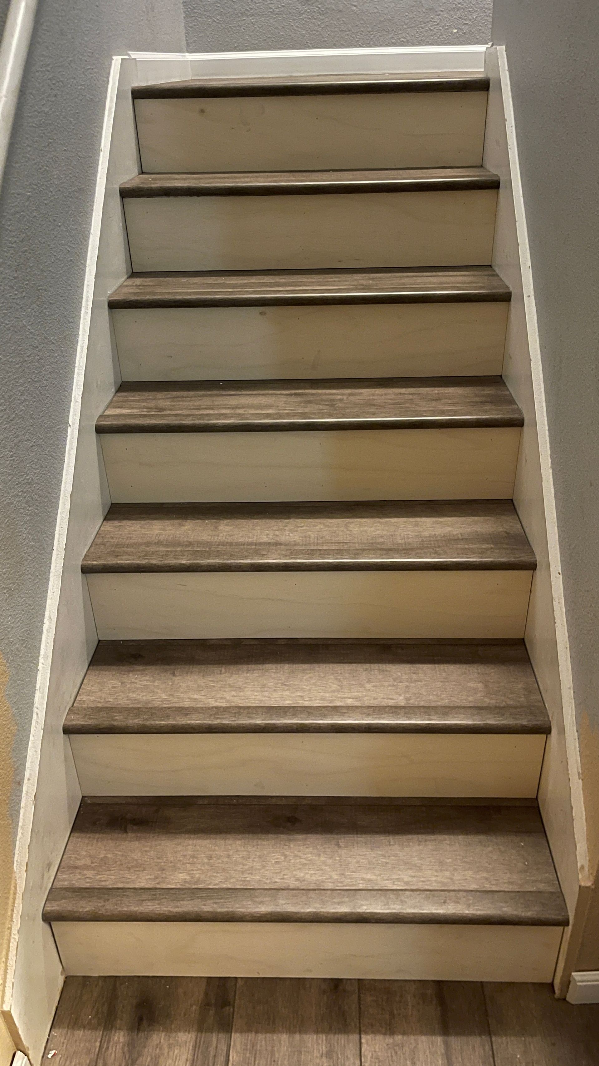 A set of stairs with wooden steps and a white railing.