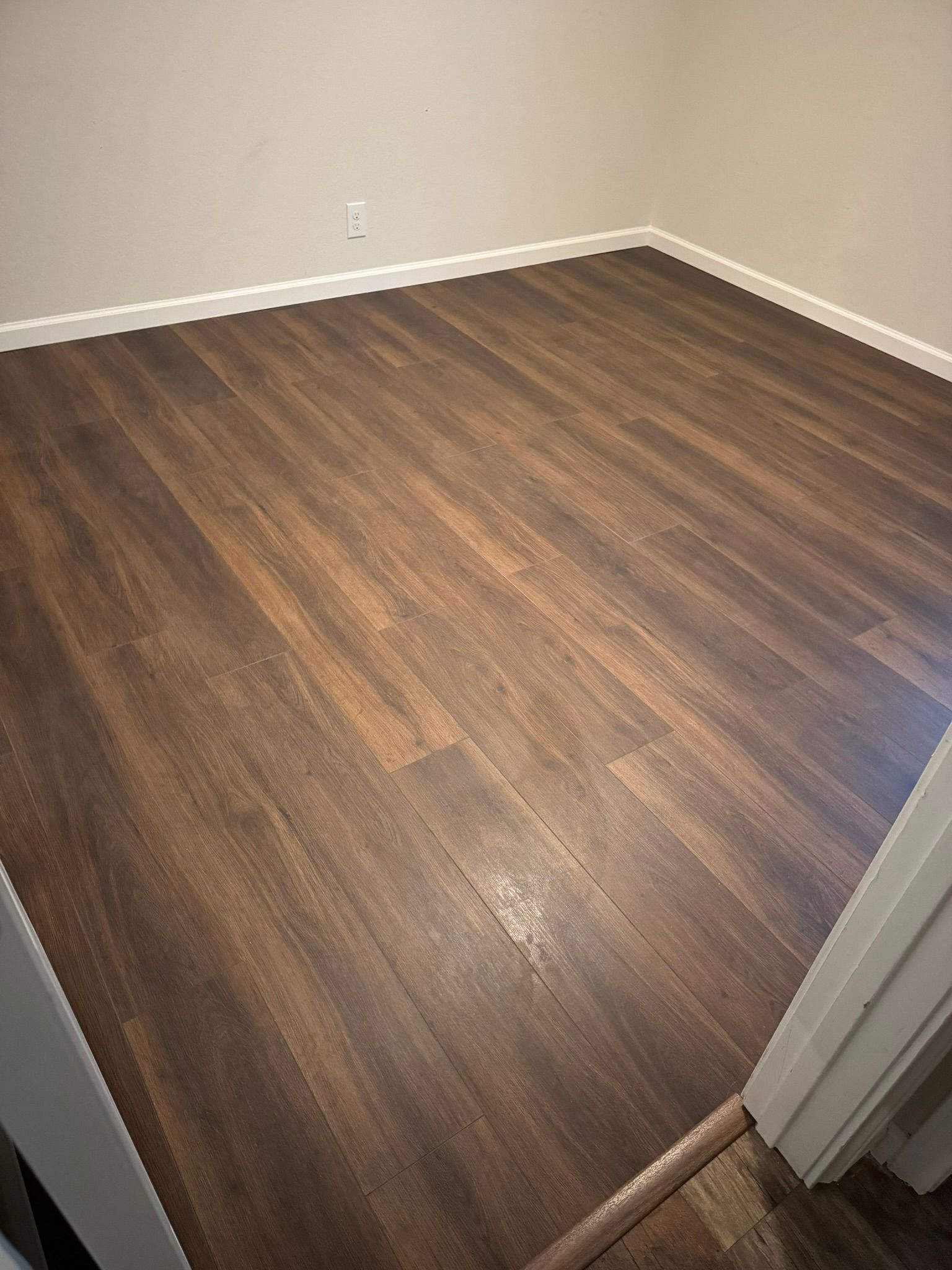 A room with a wooden floor and white trim.