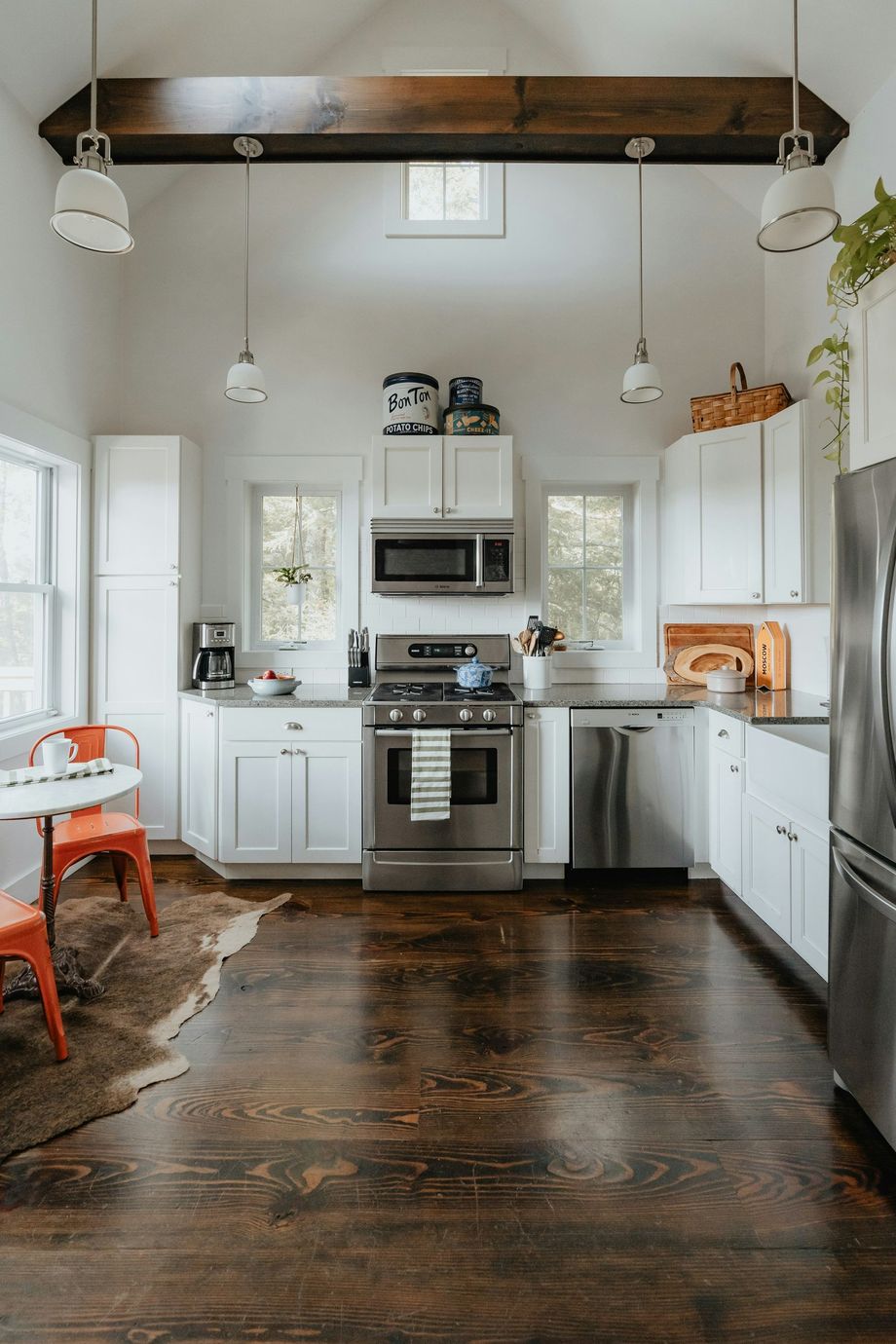 A kitchen with white cabinets , stainless steel appliances , and hardwood floors.