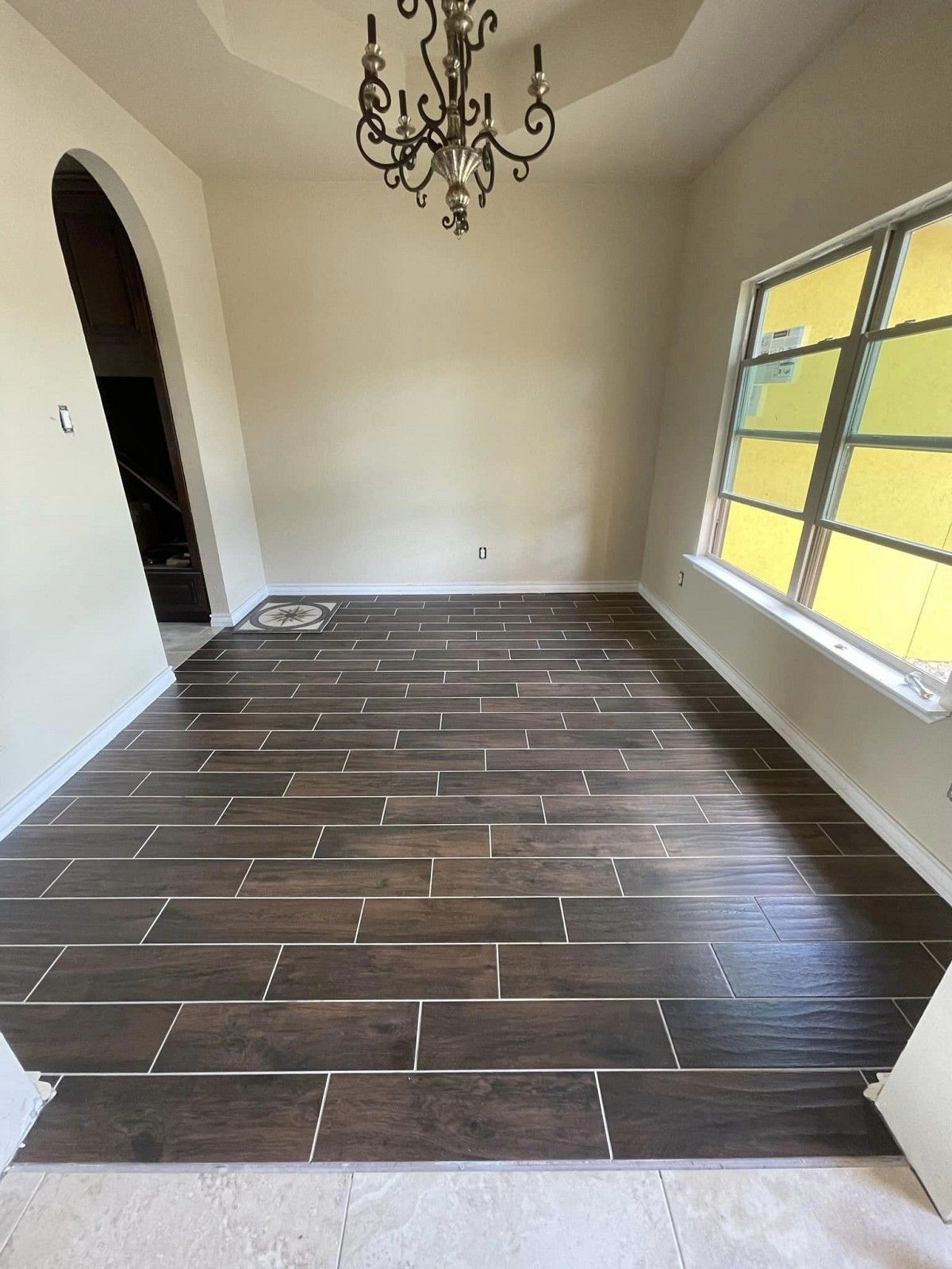 A dining room with a wooden floor and a chandelier.