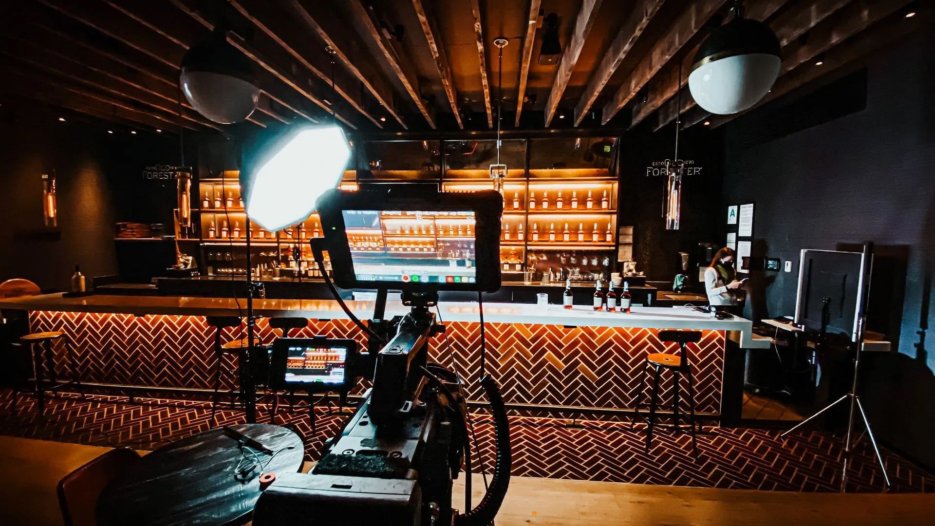 A camera is sitting on a table in a room with a bar in the background.