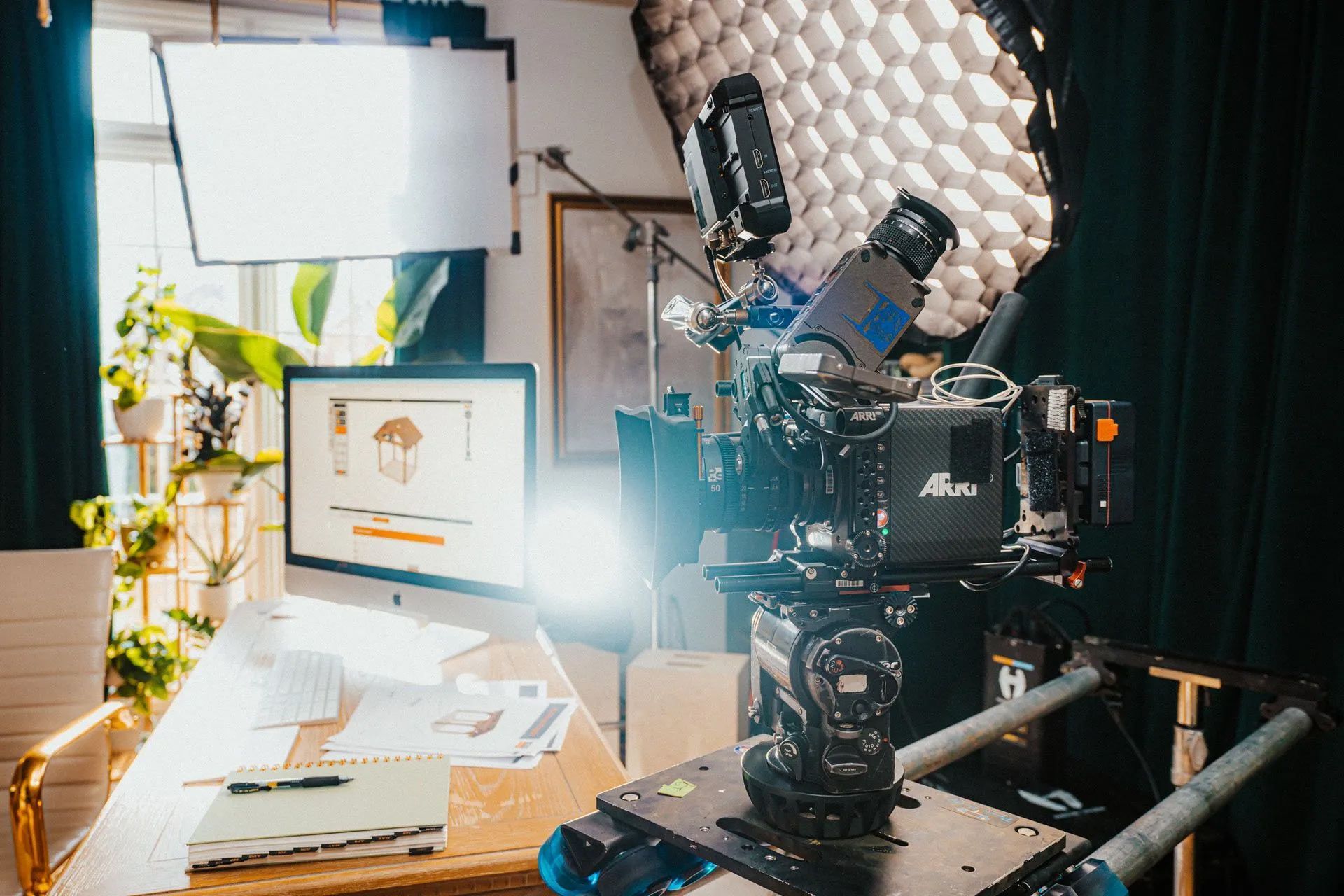 A camera is sitting on top of a table next to a computer.