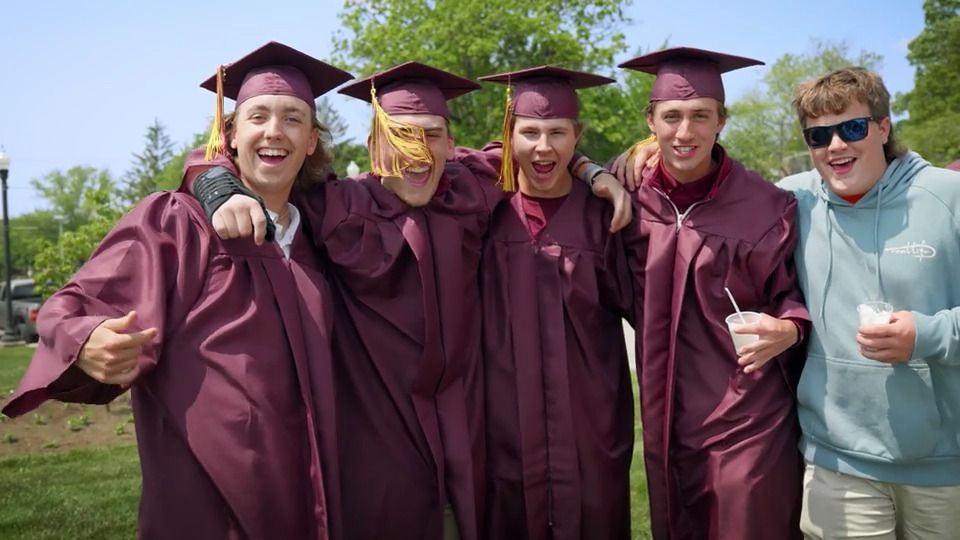 A group of graduates are posing for a picture together.