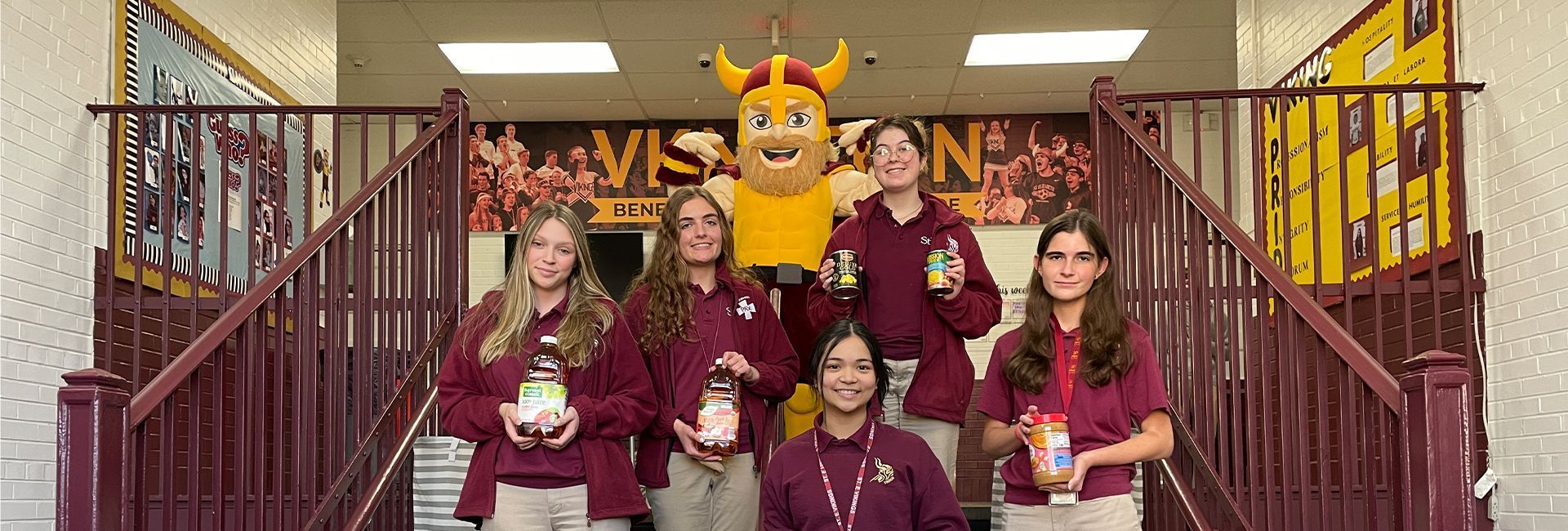 A group of students are posing for a picture with a mascot.