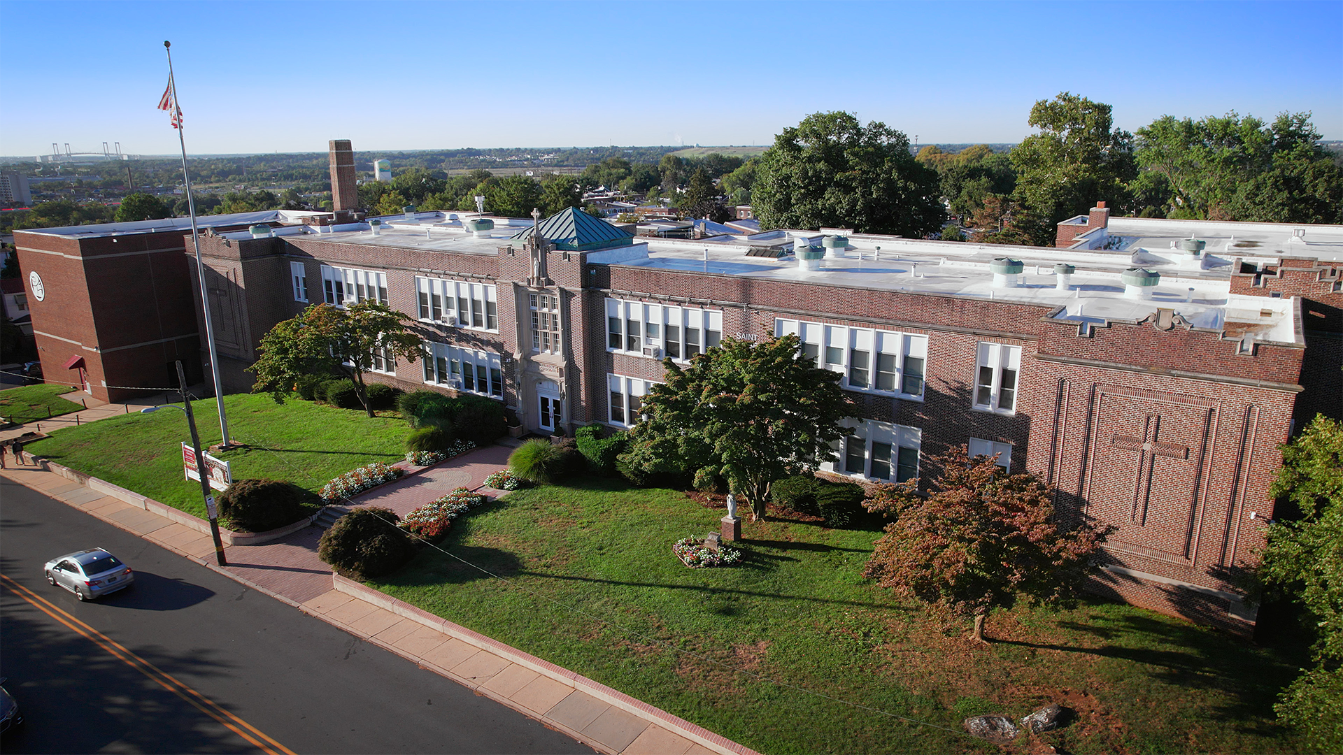 An aerial view of a large brick building with a blue roof
