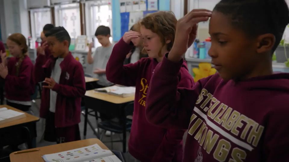 A group of children are standing in a classroom wearing sweatshirts that say elizabeth vikings.
