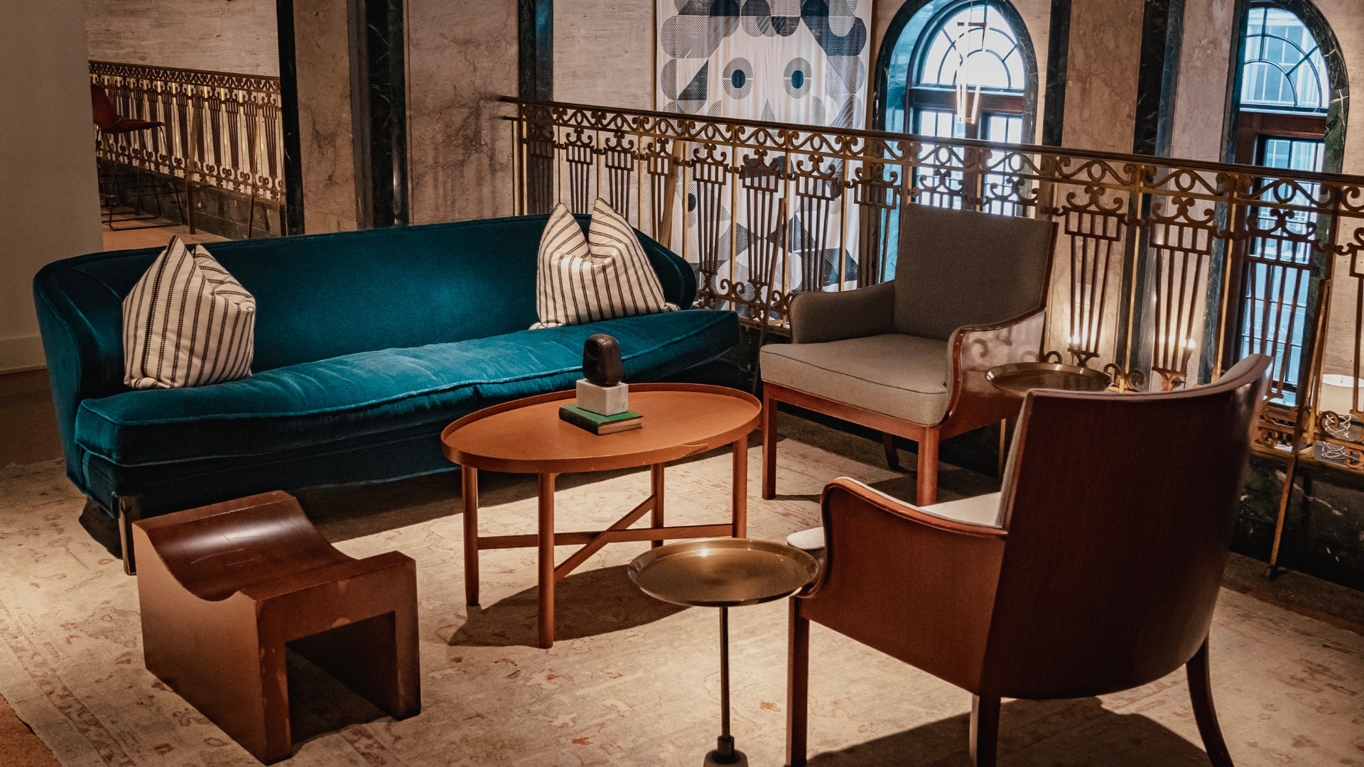 A living room with a couch , chairs , a table and a balcony.