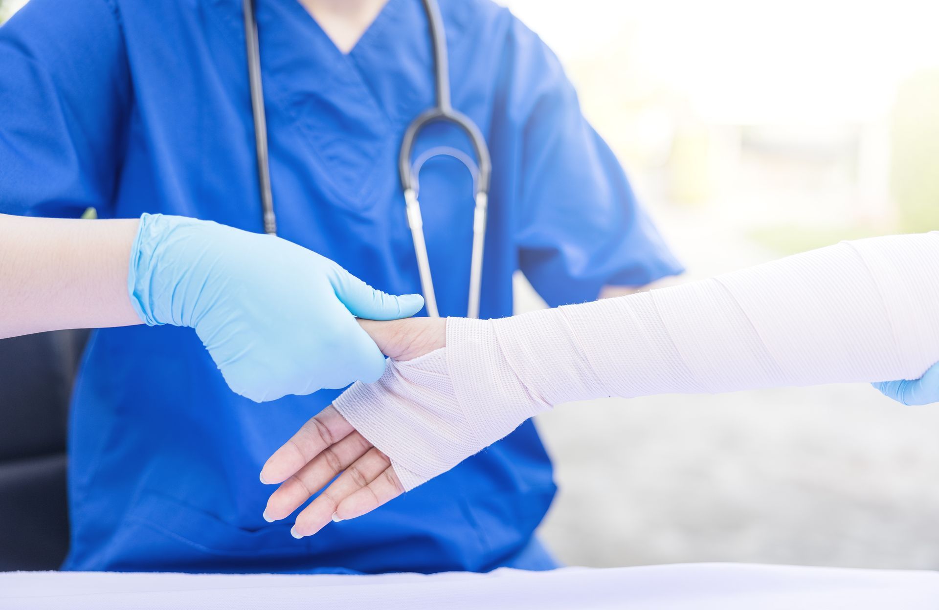 Female physician applies bandage to injured hand closeup.