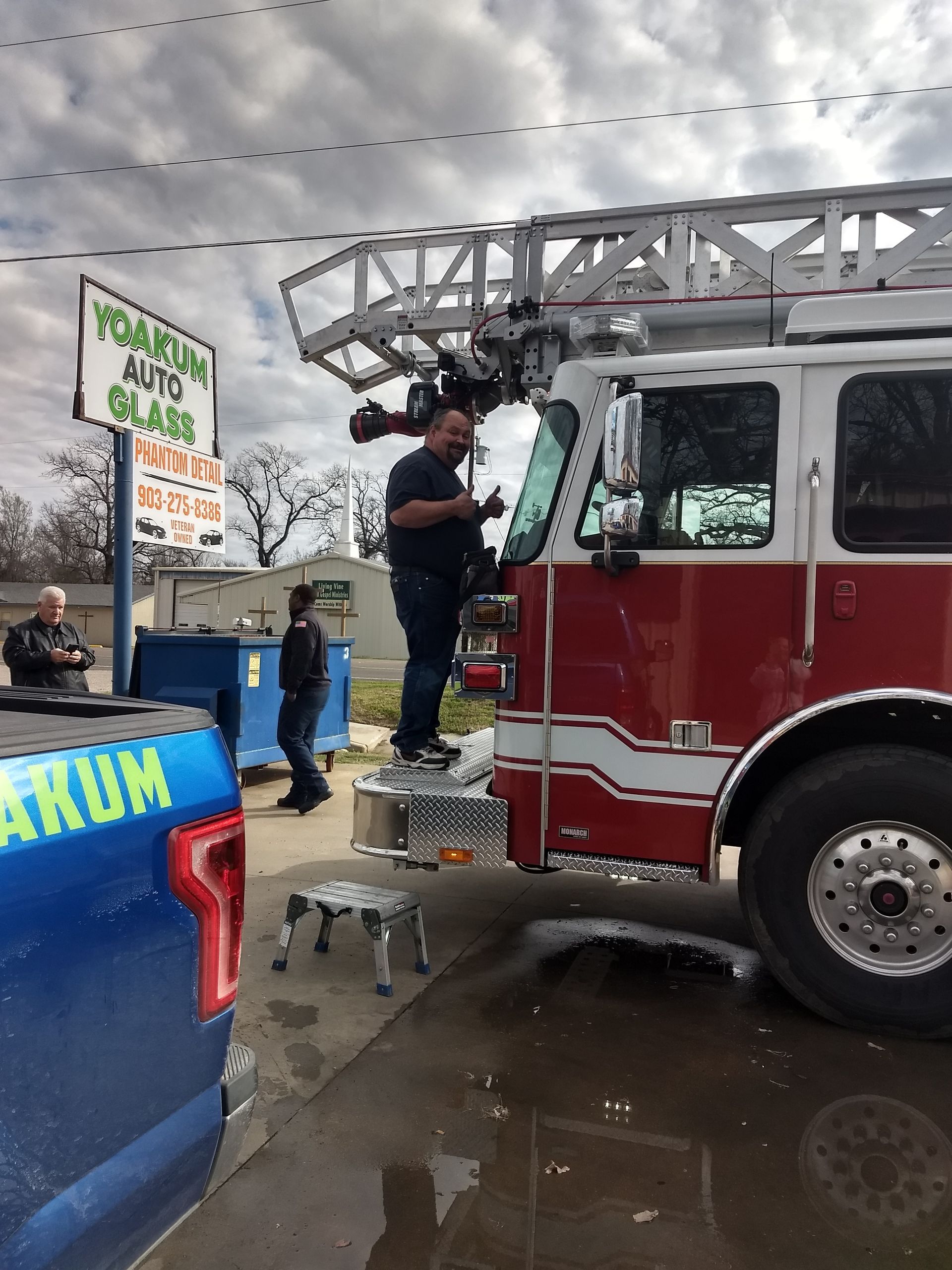 A fire truck is parked in front of a vacuum auto glass sign