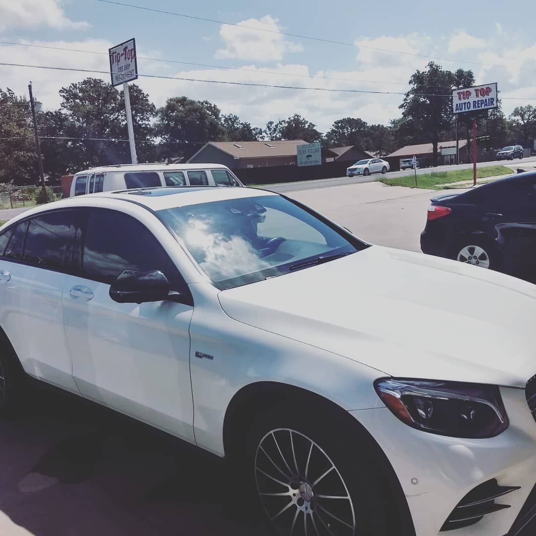 A white car is parked on the side of the road