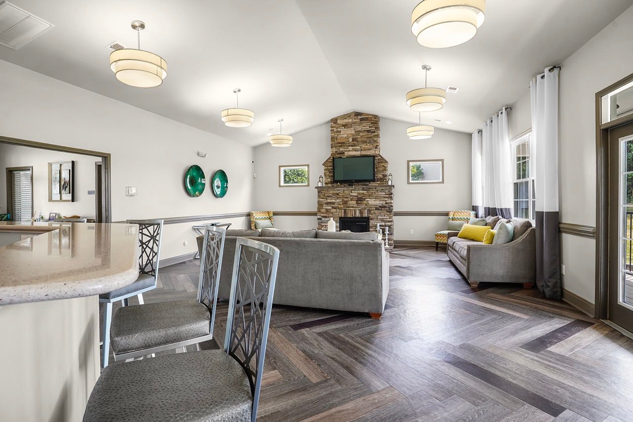 Indoor community lounge with a stone fireplace, TV, and seating area.
