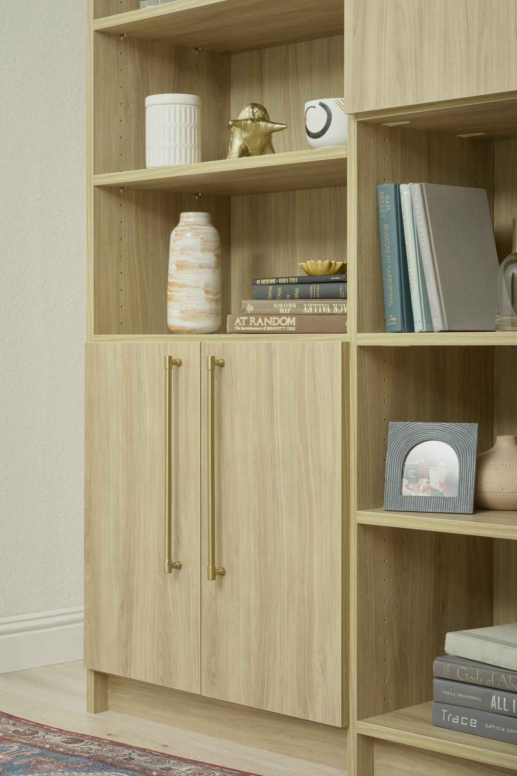 Wooden bookshelf with decor and closed cabinet doors.