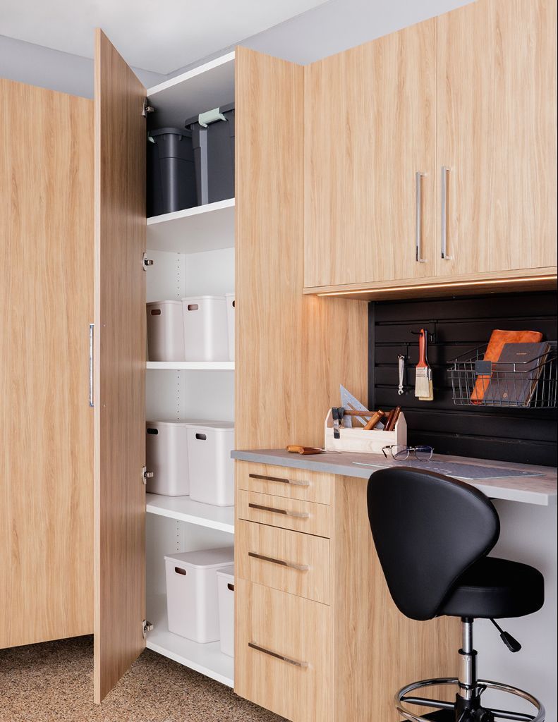 Built-in wooden office cabinets with storage boxes, desk, and black swivel chair