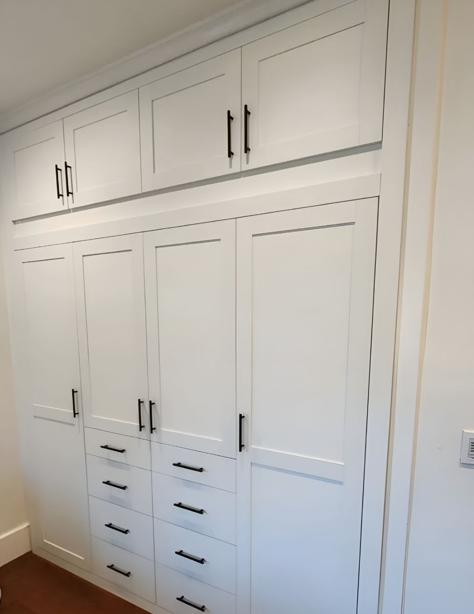 a walk in closet filled with lots of clothes and drawers .