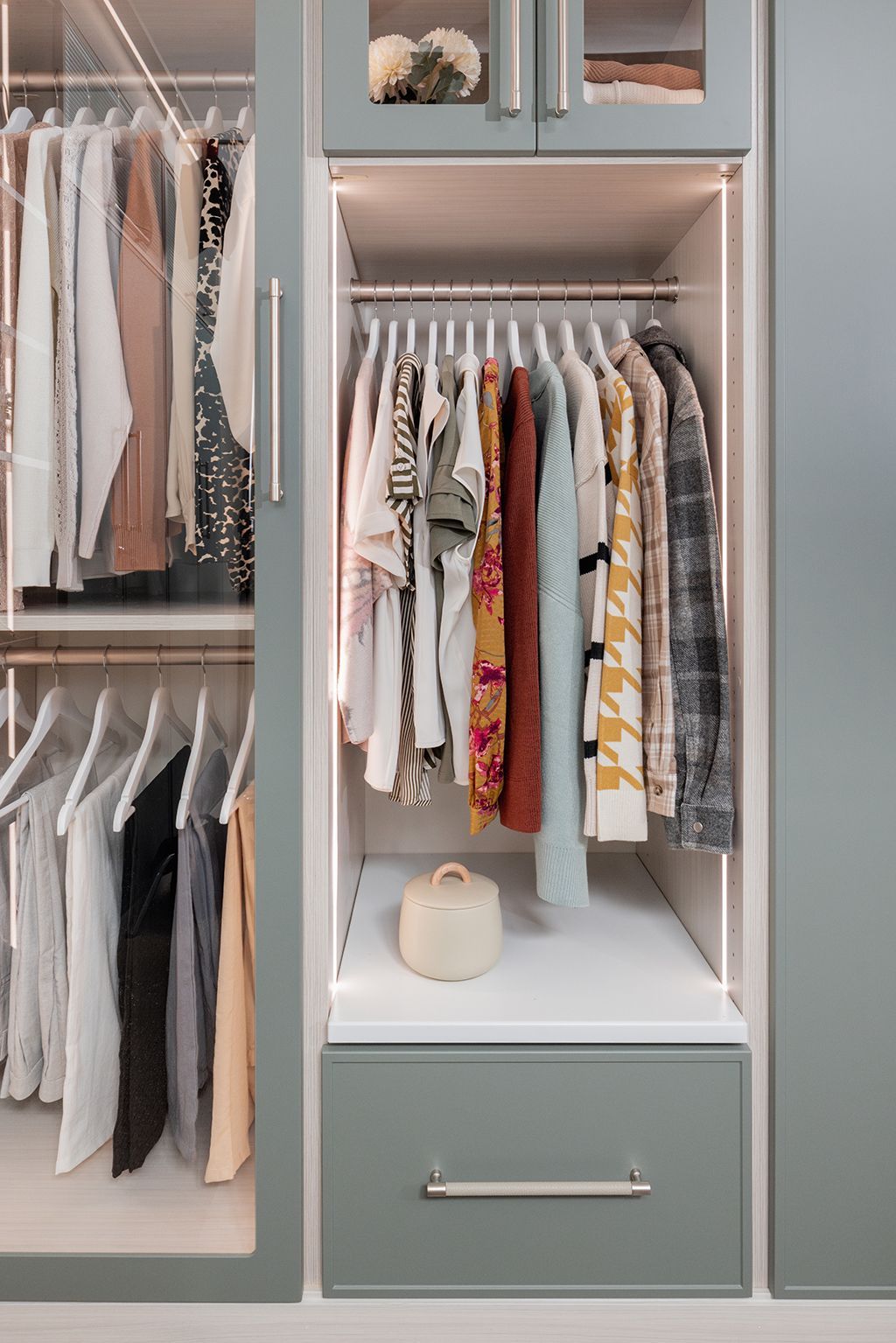 A closet filled with clothes and a drawer.