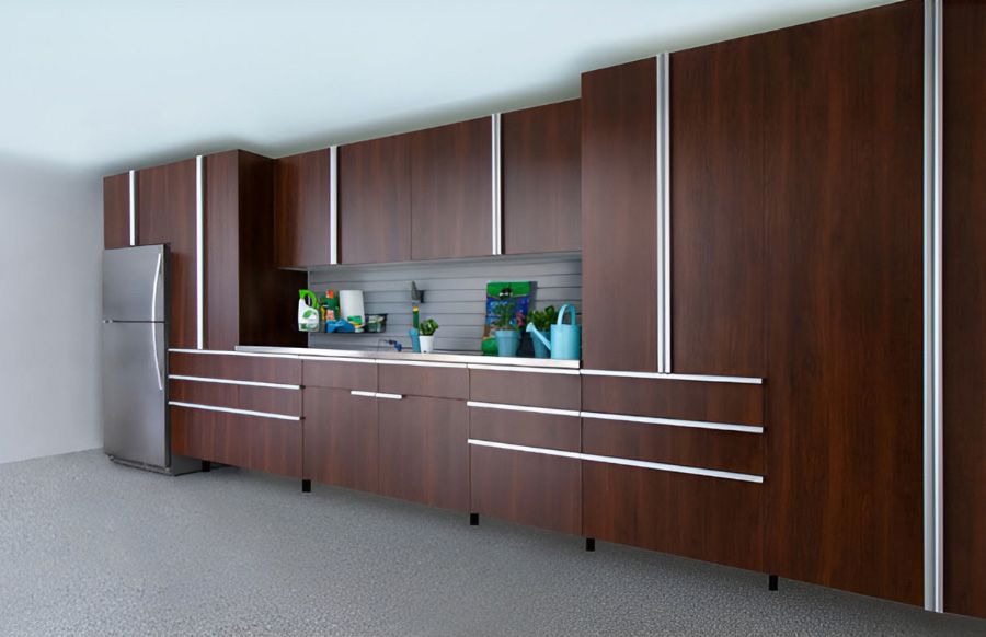 A garage with wooden cabinets , a desk and a chair.