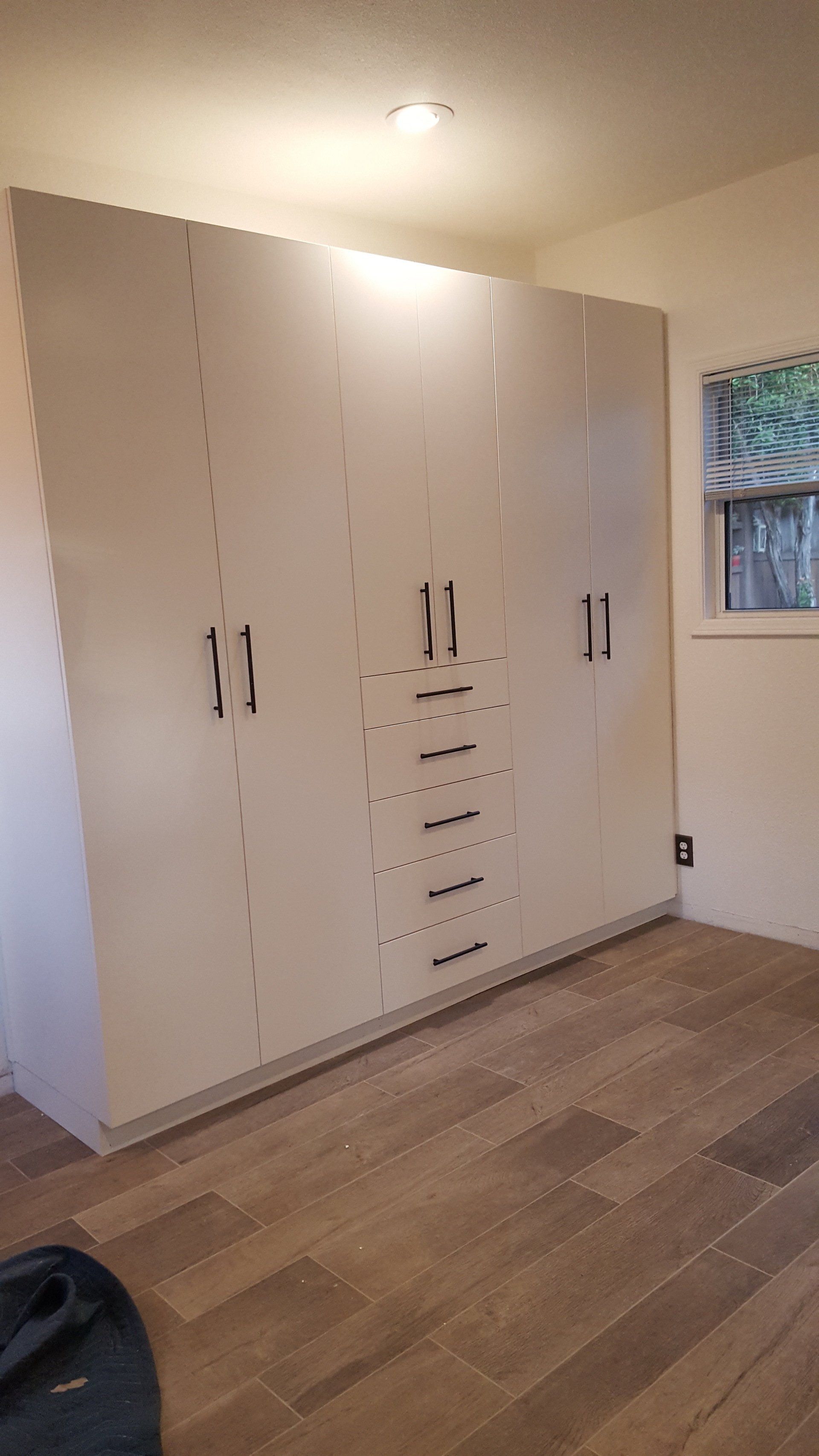 A room with a lot of cabinets and a window.