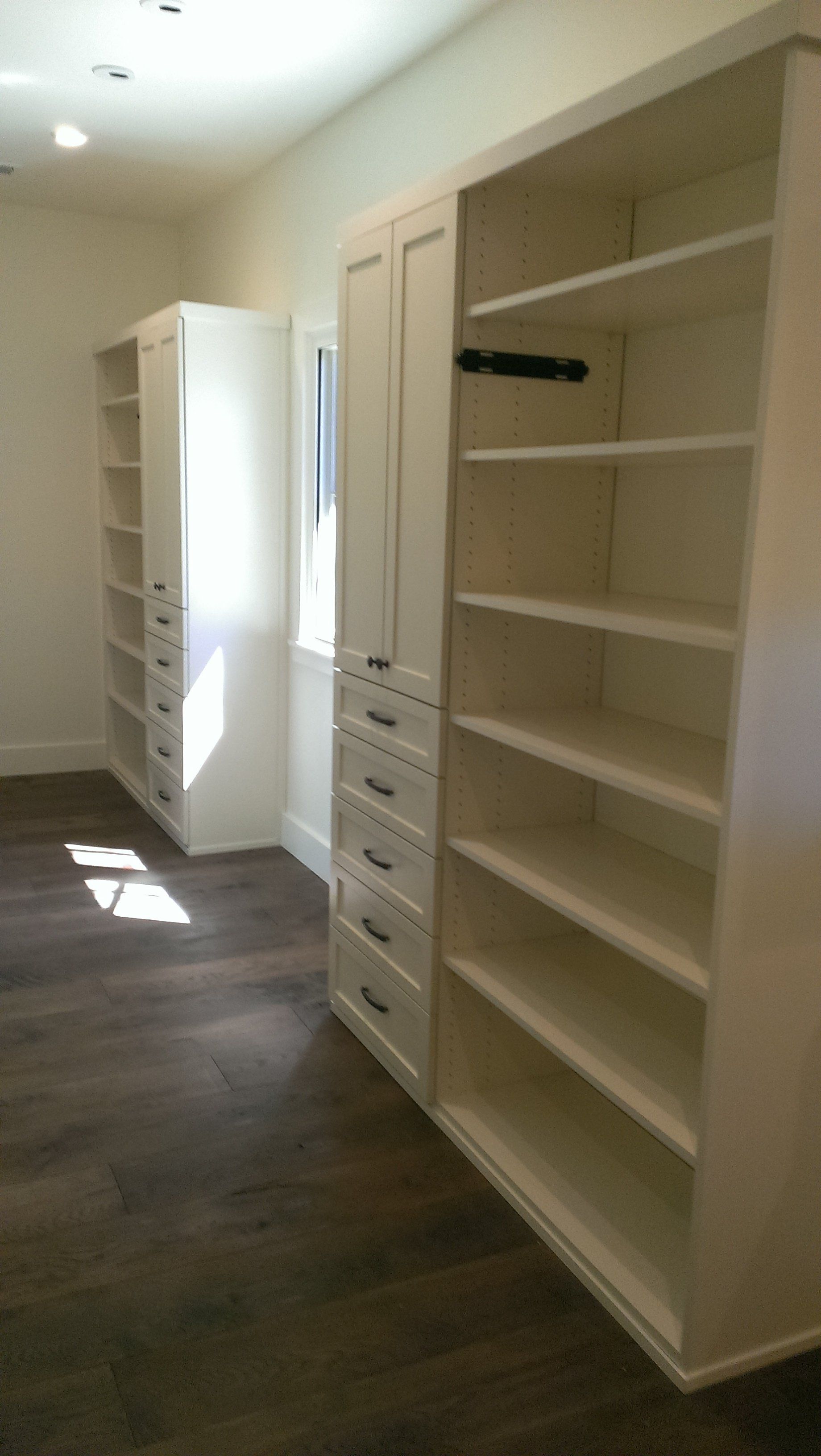 A walk in closet with lots of shelves and drawers.