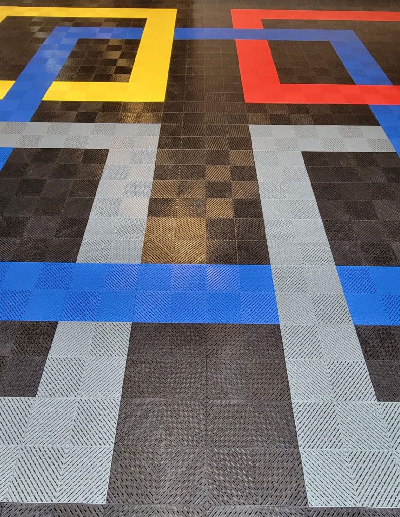 a garage with a multiple color tile swisstrax flooring