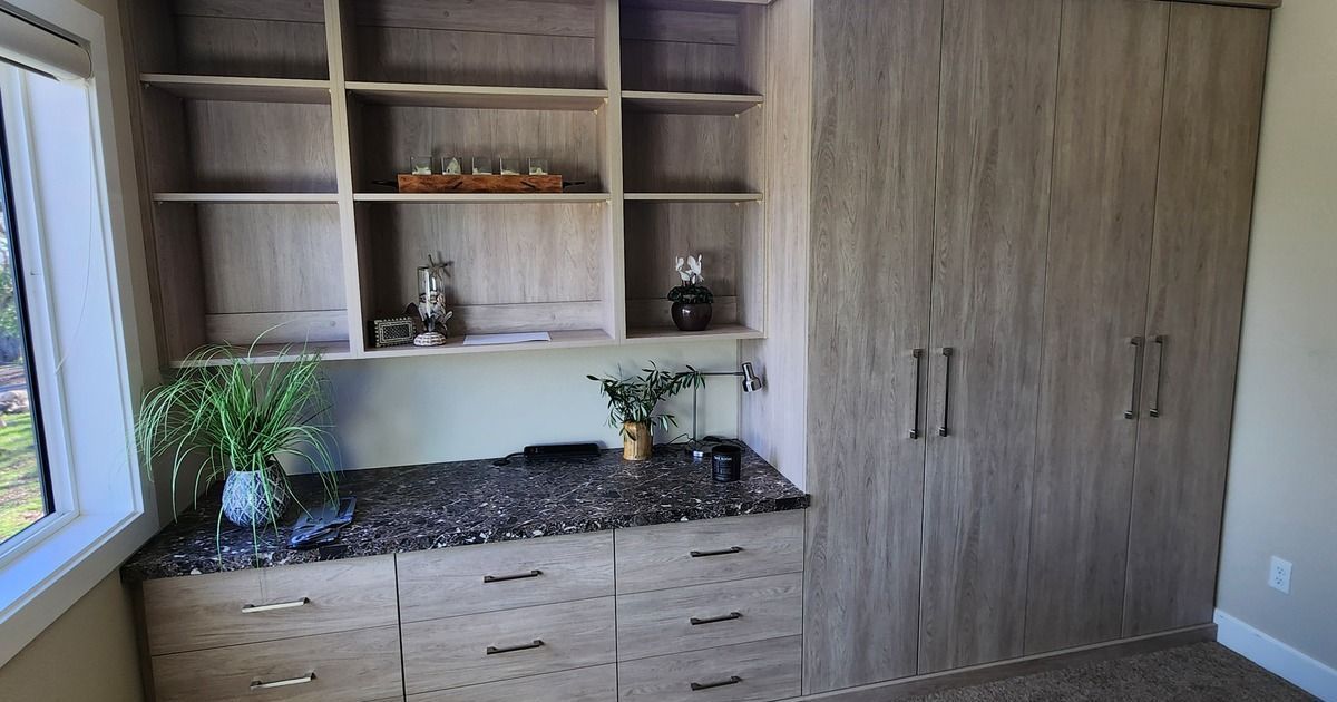 A room with a lot of shelves and drawers and a window.