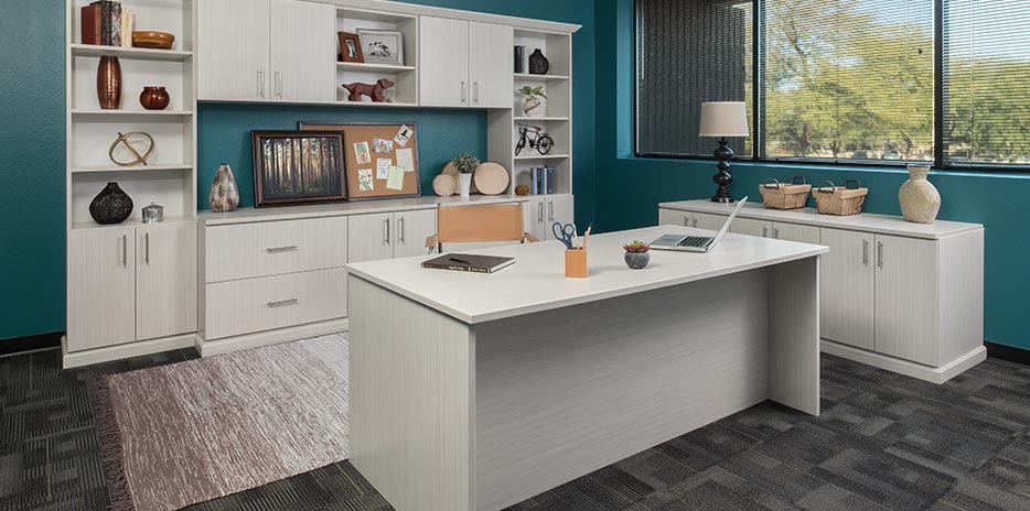 a home office with a custom cabinet system complete with a desk