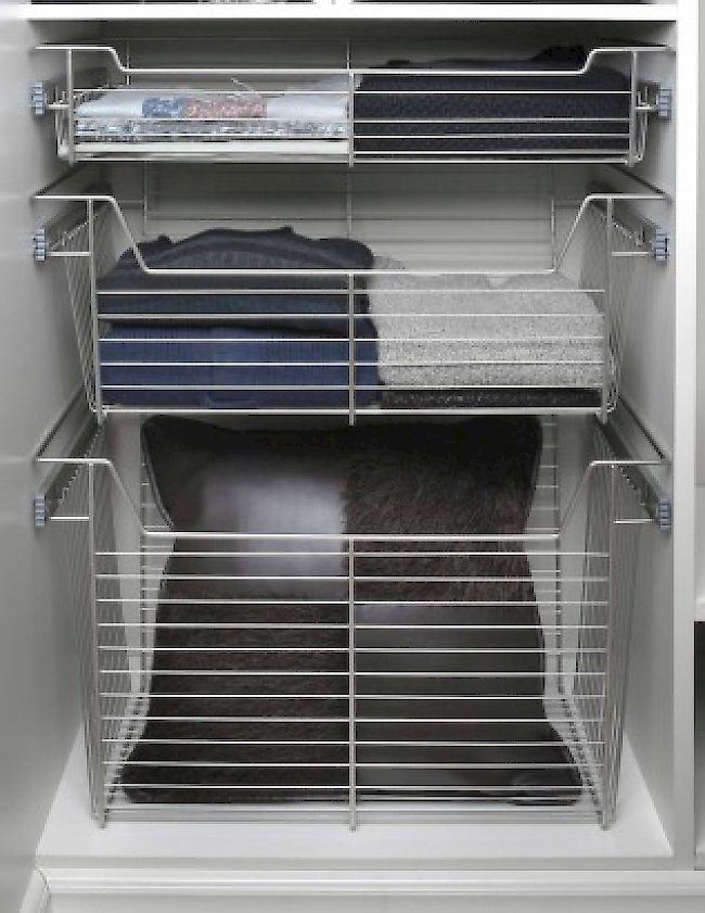 a closet filled with clothes and pillows .