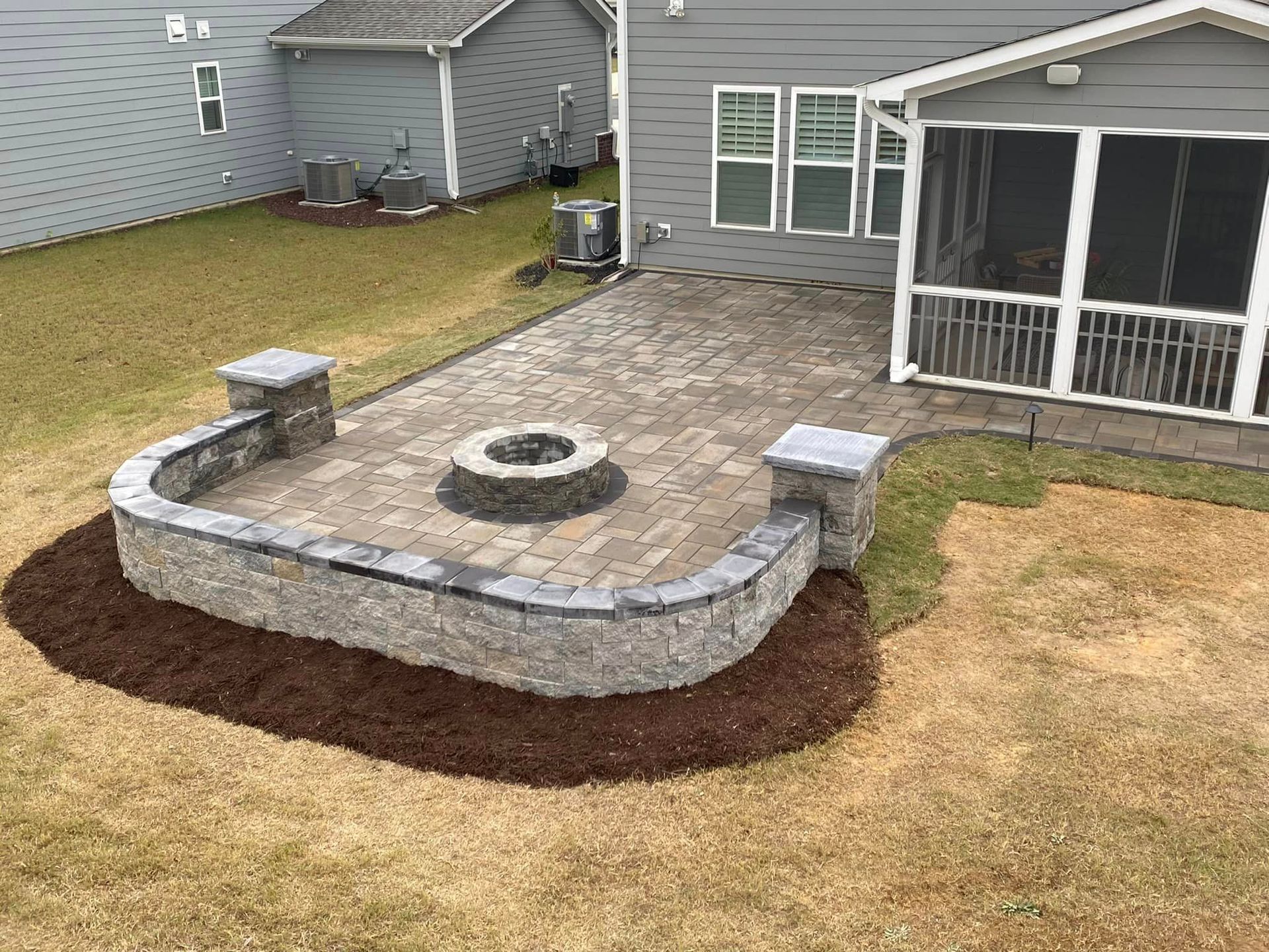 There is a fire pit in the backyard of a house.