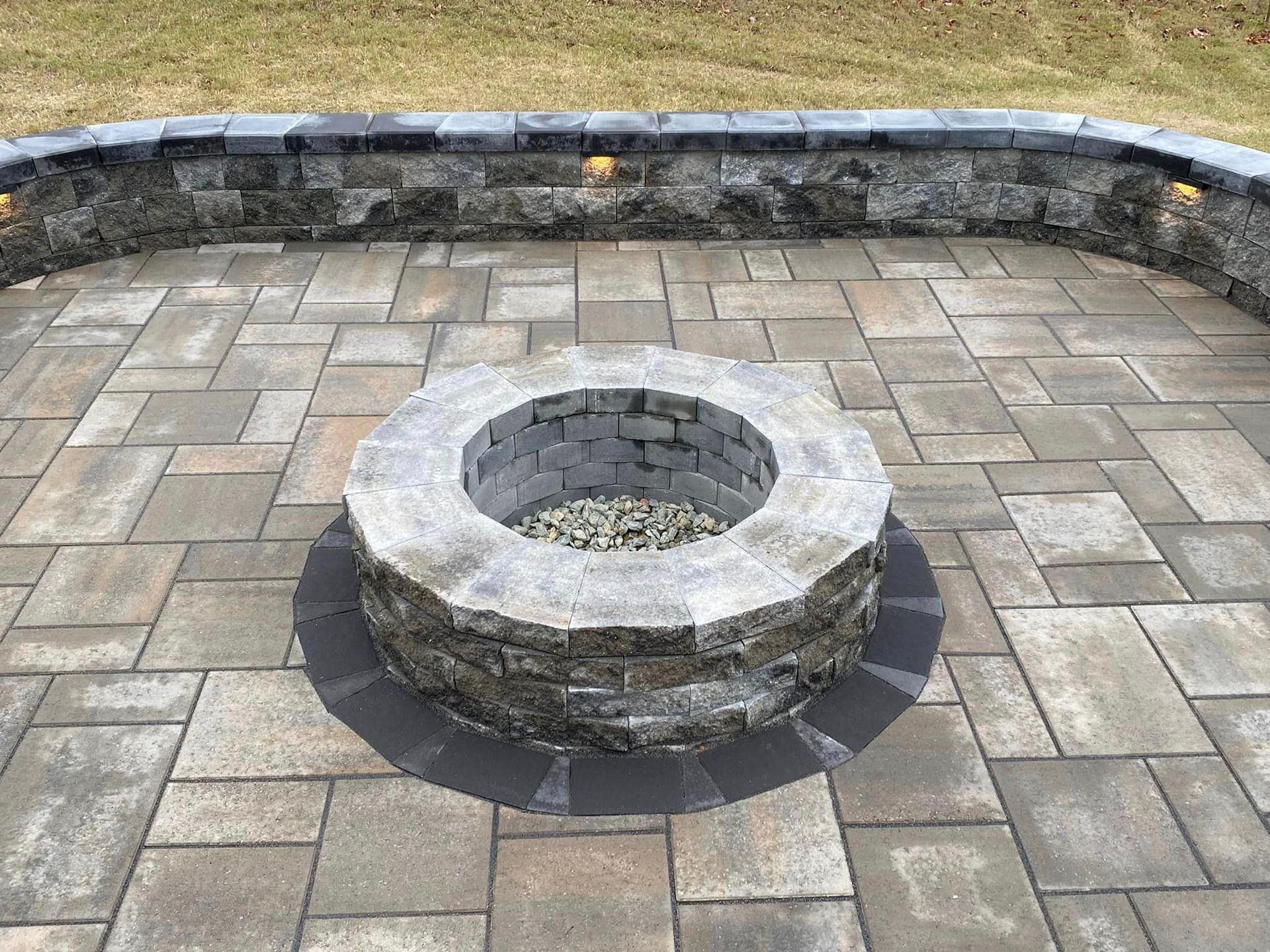 A fire pit is sitting on top of a brick patio.